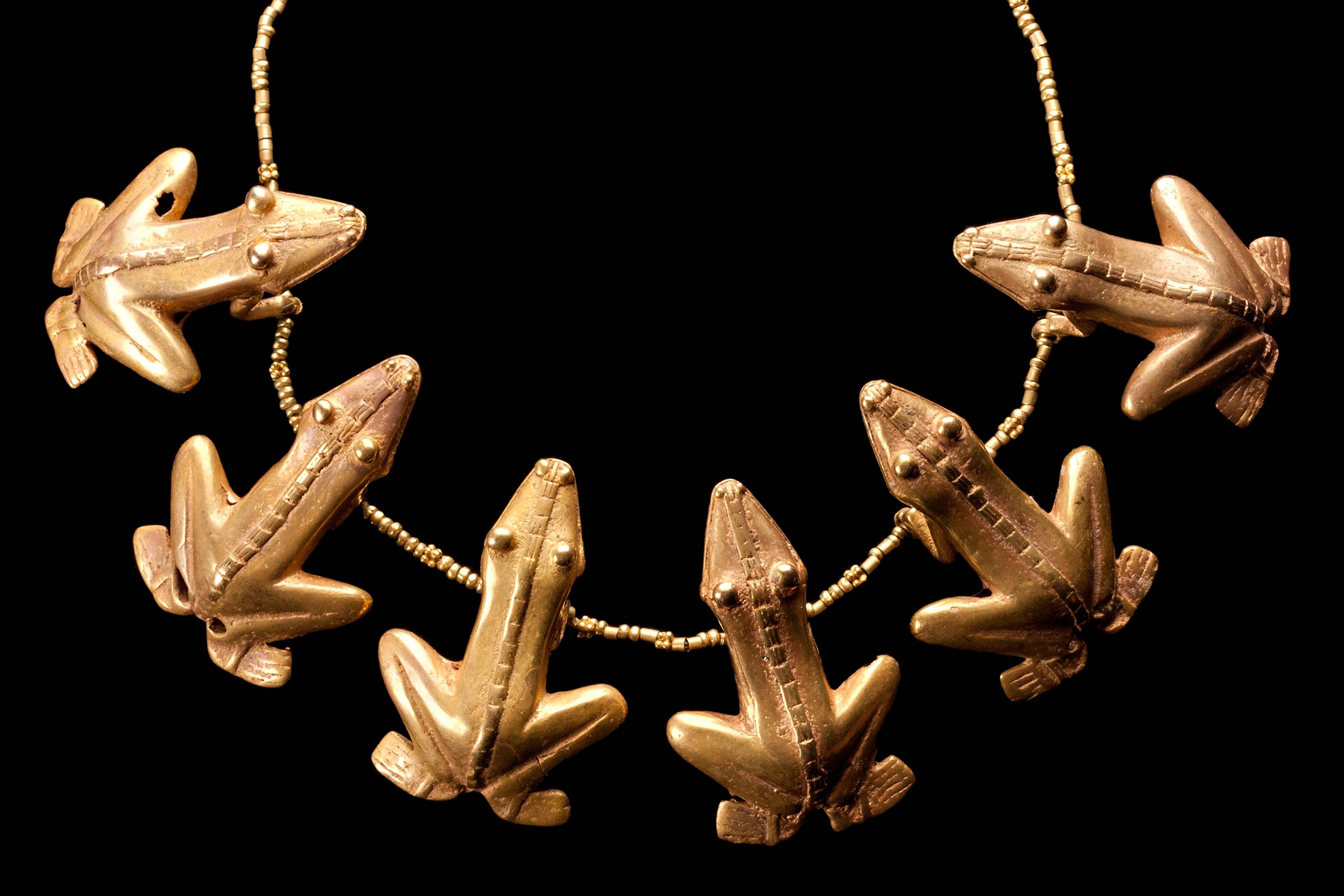 Gold Quimbaya necklace with beads in the shape of six frogs of delicate and slender shape with a beautiful gold color and patina, very nice expression with two narrow lines on the back, segmented by horizontal lines. The frogs are associated to