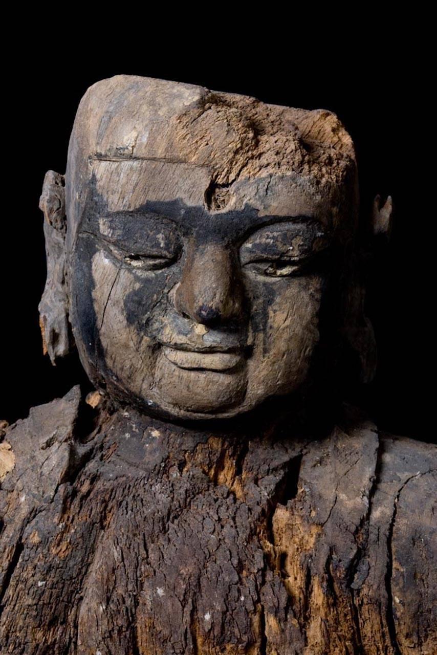 Very serene depiction of a Lohan carved in wood, eroded with the pass of time. Lohan is the Chinese term, derived from the Sanskrit word Arhan, for a disciple or follower of Buddha who has reached a state of enlightenment. The Lohan had been a