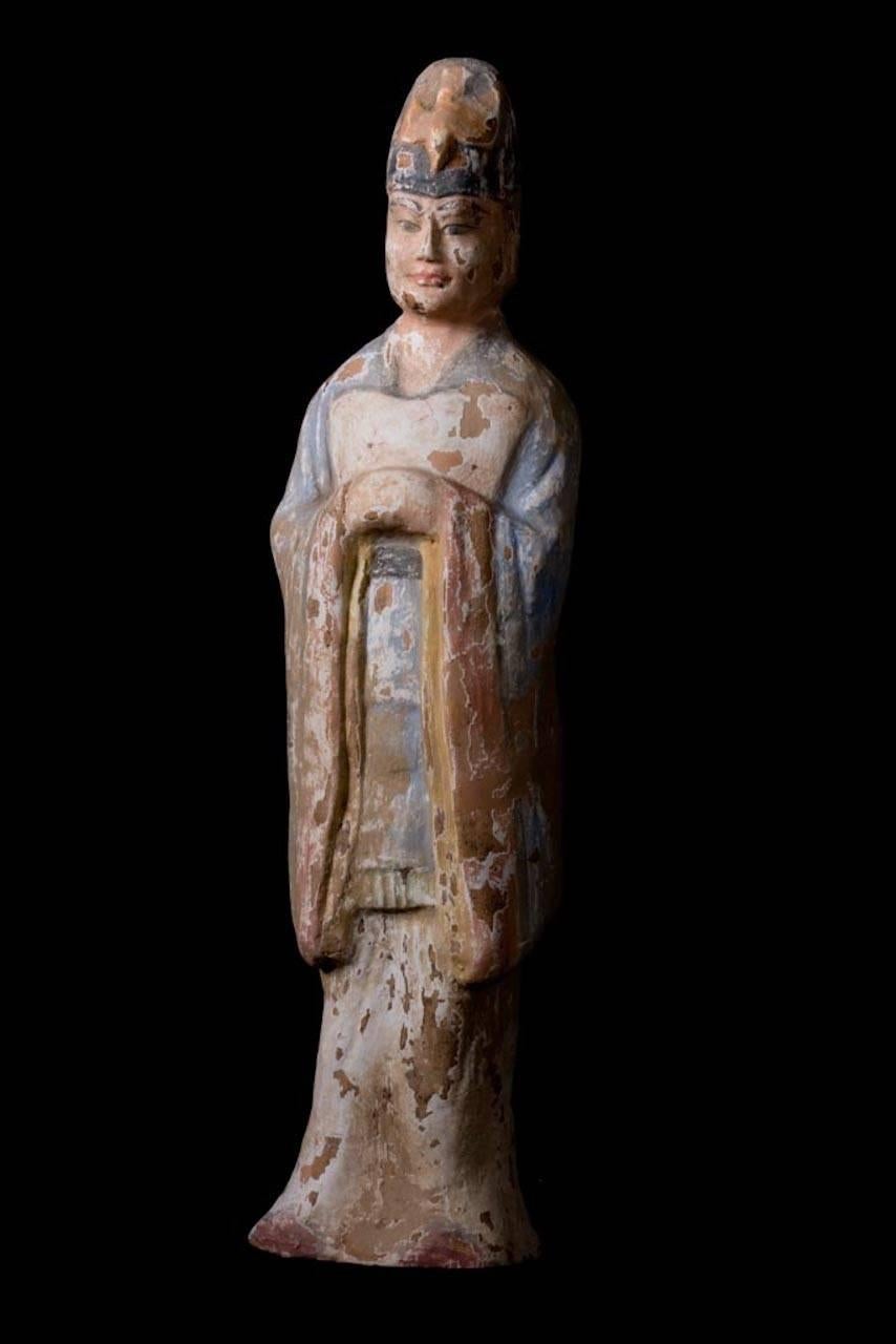 Elegant Standing Court Dignitary with joined hands in blue robes and a bird headdress. Polychrome Traces. 

When China was unified again, first briefly under the Sui and then under the long and prosperous Tang, mingqi truly resurged as a part of