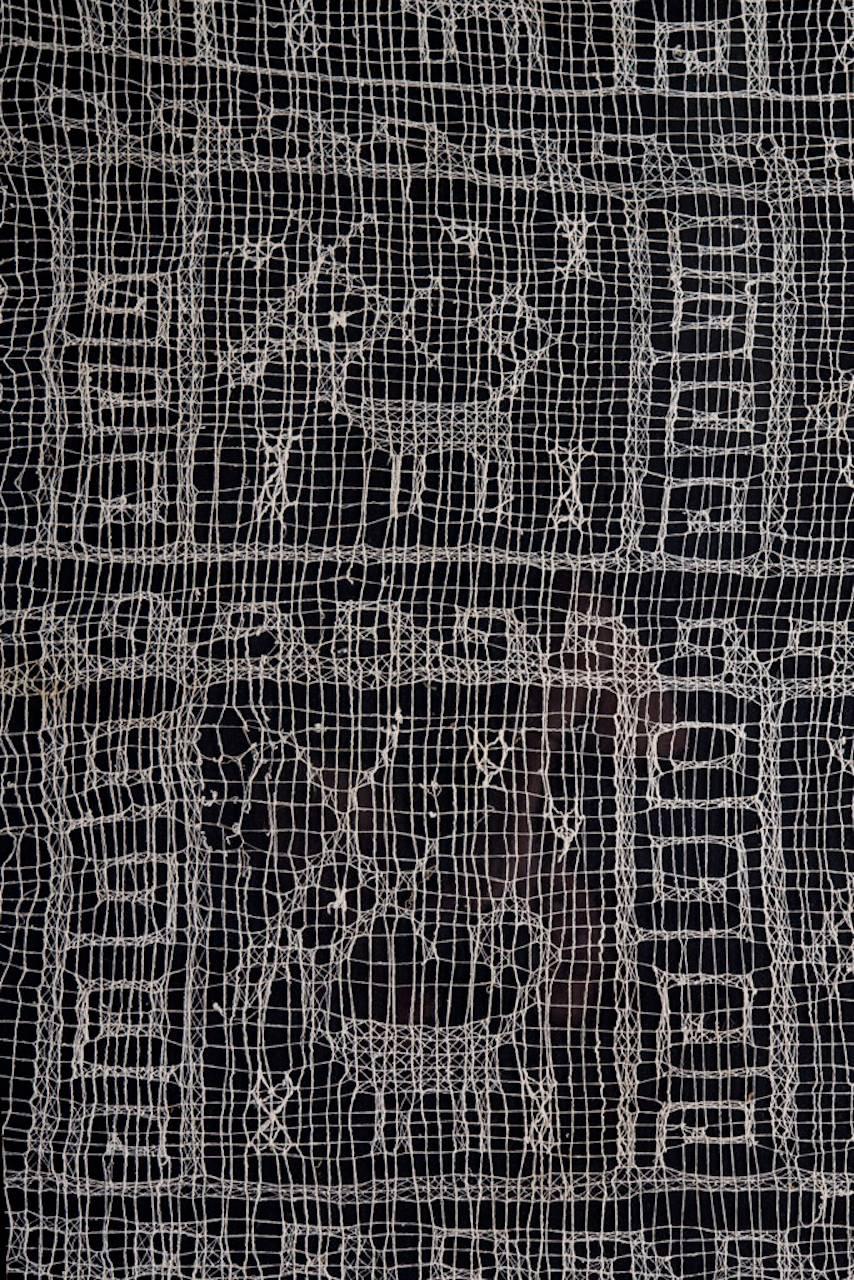 Large, rectangular section of loosely woven cotton in an open, net pattern weave. Bears three complete selvedges and has 12 square sections, each containing a horned animal with curled tail surrounded by a meandering, geometric border. Excellent