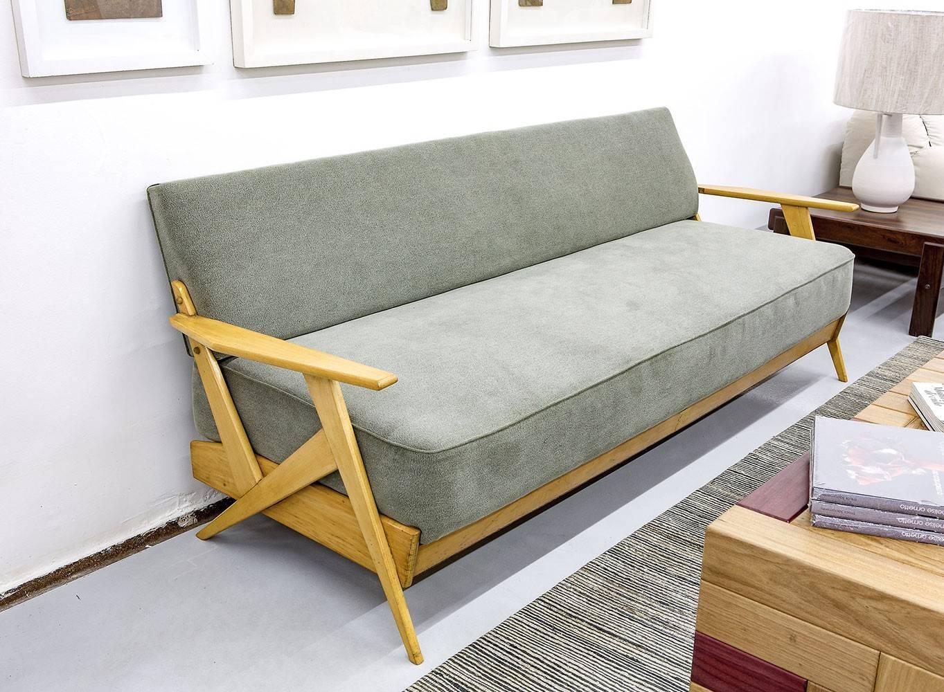 Ce canapé du milieu du siècle, en bois et tissu gris, a été produit dans les années 1950 à São Paulo par le studio de Zanine. Il s'agit d'un bon exemple de ses premières pièces.

José Zanine Caldas était un designer, un architecte et un artiste. Son