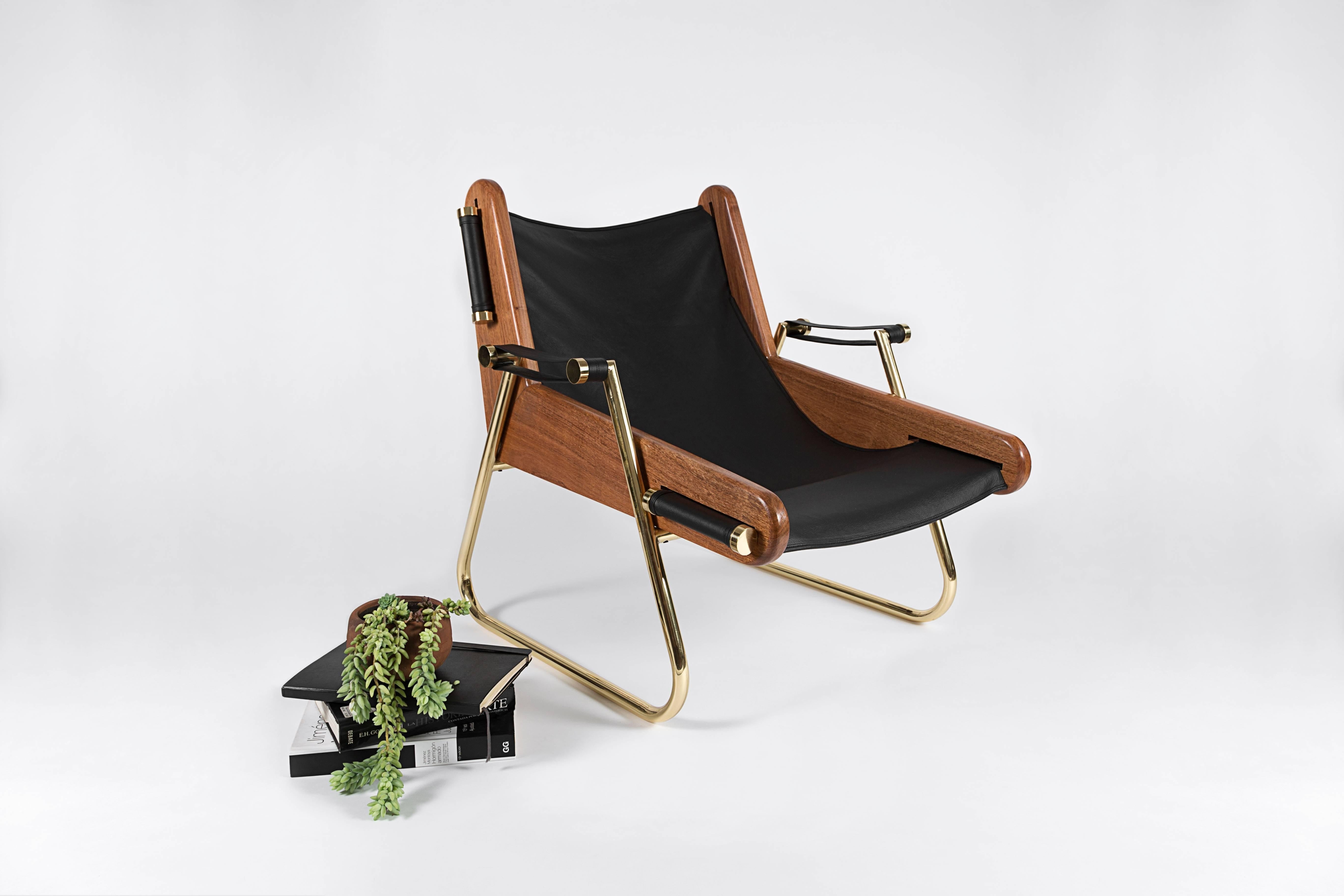 Form meets function in this sleek yet extremely comfortable suspended leather sling chaise. All materials are sourced locally specifically for each piece and handcrafted. Mexican walnut hardwood, double thickness bovine leather and varnished brass.