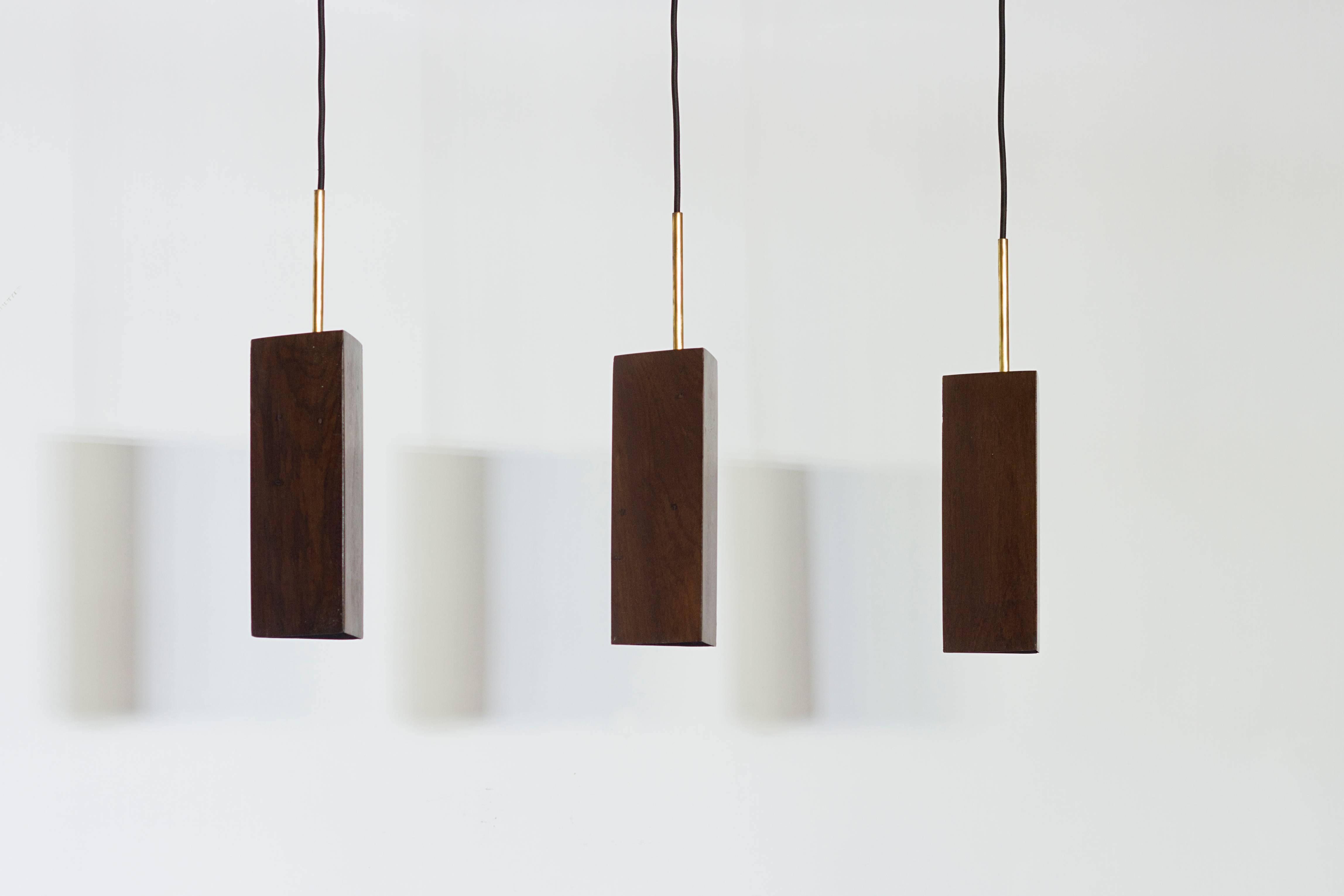 This pendant lamp is made in Brazilian Canela Preta reclaimed dark wood and brass. 
Different types of wood available upon request.
Ready for E27 lamps.