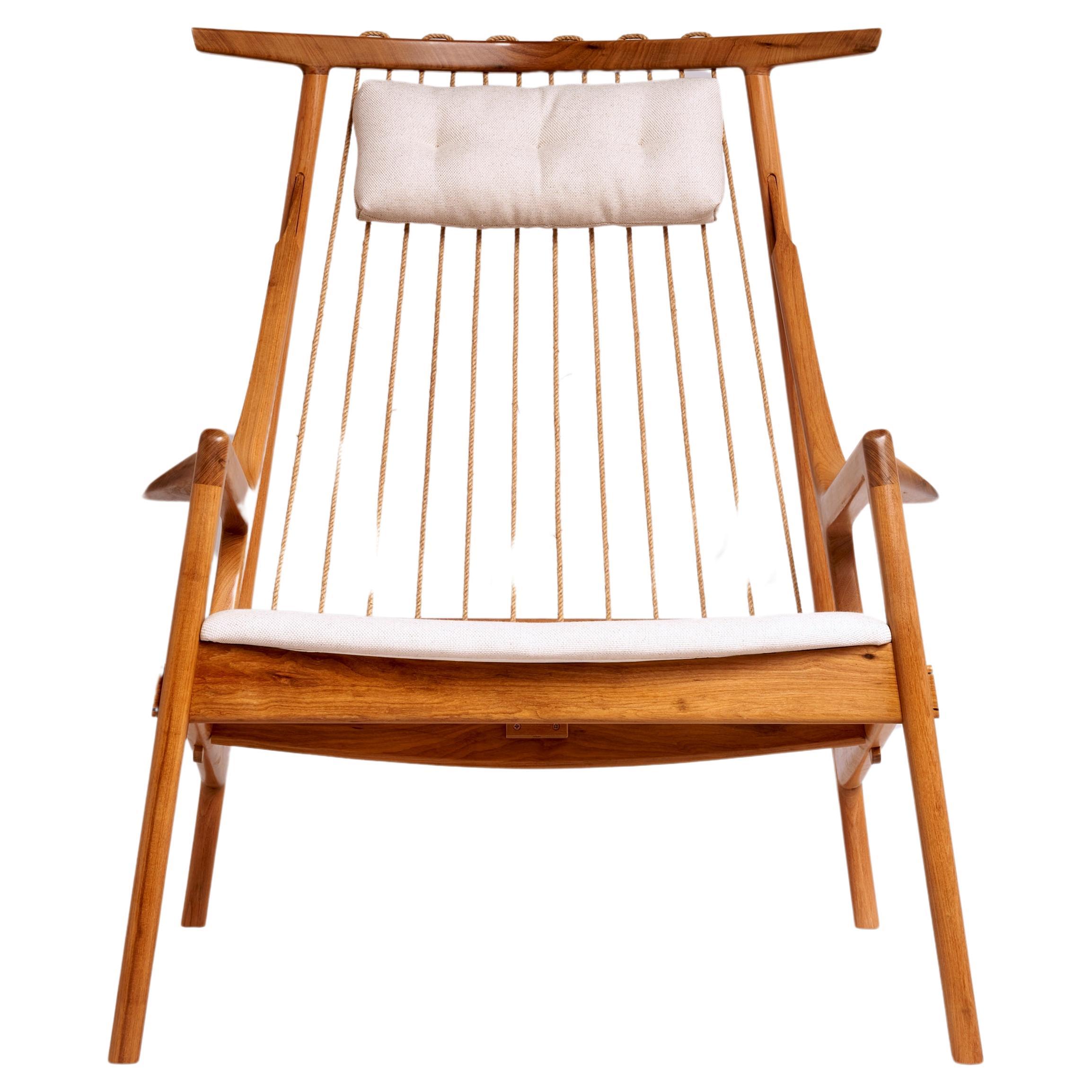Contemporary armchair made with reclaimed tropical hardwood, upholstered seat and head cushion in linen.

The backrest is made with rami cord, a vegetable fiber, which is twisted and treated.

This piece can be produced by demand in some of our
