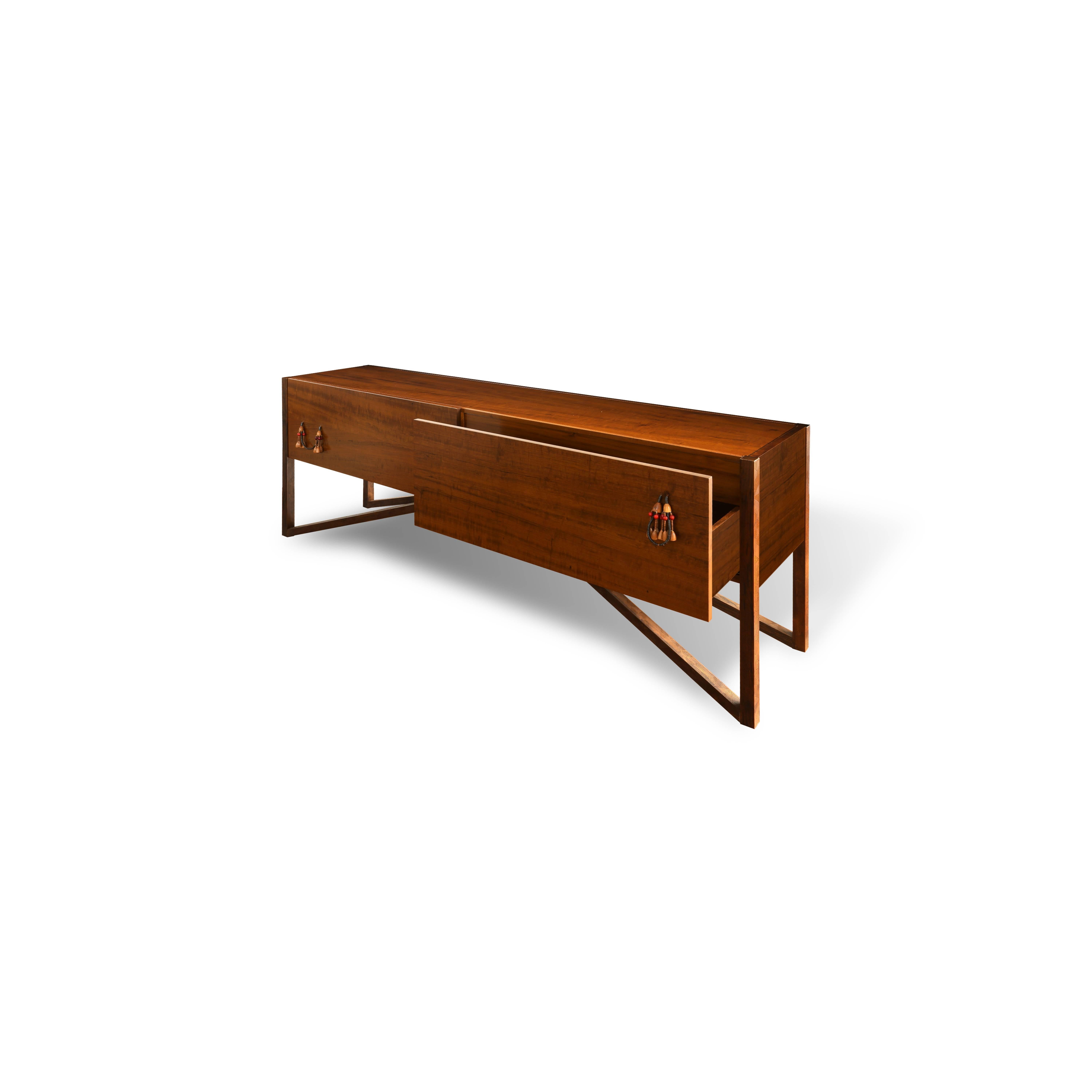 The Tribos buffet Credenza received a honorable mention at the  Job Trainnig Girona Panamericana School in 2014, São Paulo.  It is made of Brazilian imbuia hardwood with pendants details made by the nambiquaras' tribe, in Mato Grosso, Brazil, and