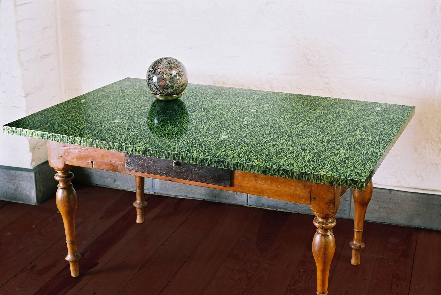 19th century table made of turned cedar wood, covered with a sheet metal plate with printed grass and silver handle.