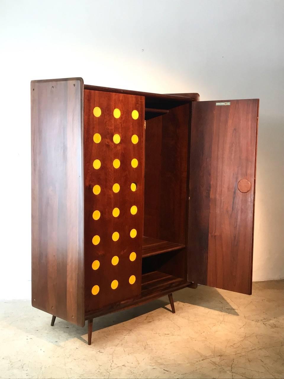 Midcentury armoire or clothes-press made of solid imbuia wood and yellow details. This is an important piece of the modern Brazilian furniture made by Cimo that was furniture maker specialized in office furniture, they made only a few home furniture