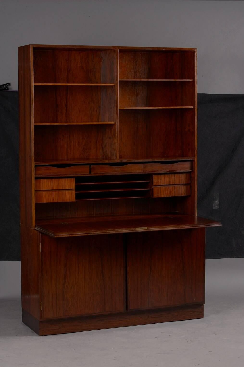 Danish rosewood wall unit and desk by Gunni Omann for Omann Jun.

Measure: Base 47.25in L x 17in D x 27in H; bookcase: 47.25in L x 12in D x 46.75in H.