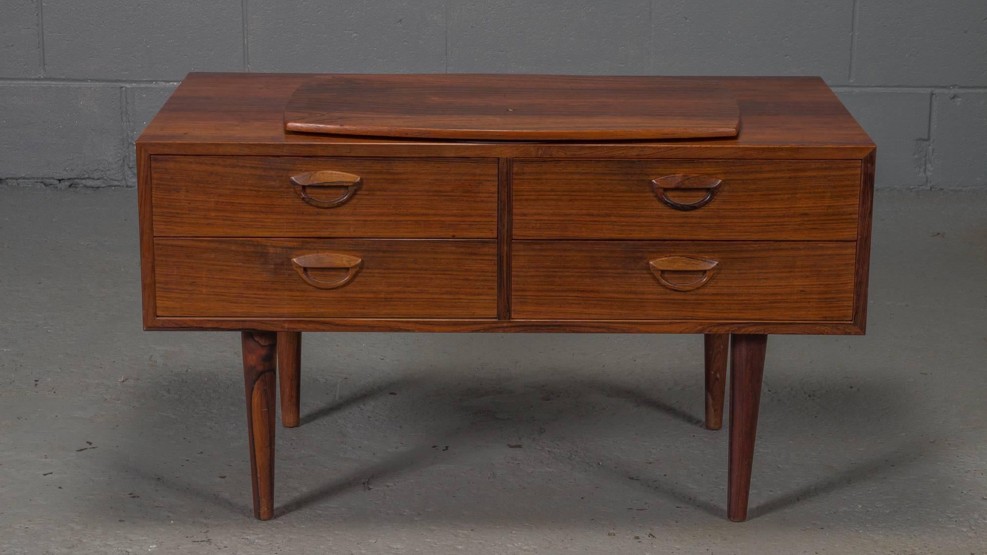 Kai Kristiansen designed this rosewood chest with four drawers, tapered legs, and a spinning TV stand.