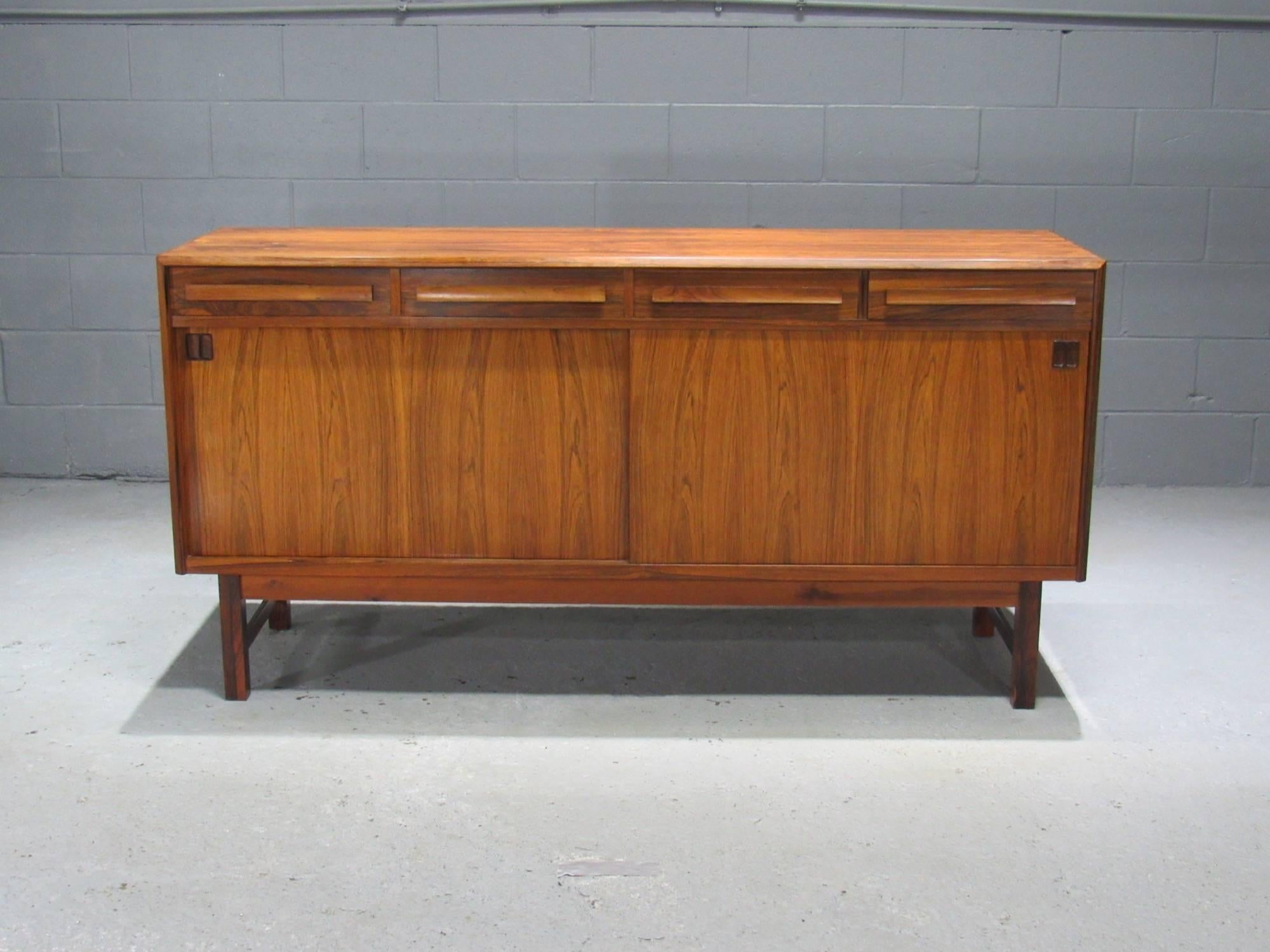 Danish Modern Rosewood Sideboard by Bordum OG Nielsen, This sideboard features a beautiful rosewood grain. With four drawers above two sliding doors which reveal ample storage and adjustable shelves. The right two drawers have felt-lined cutlery