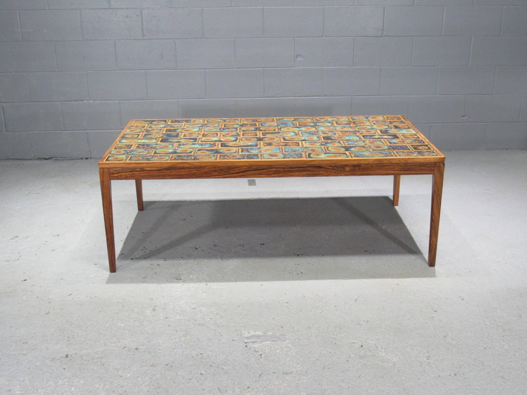Large Danish Modern Rosewood and Tile Coffee Table. This stunning tile coffee table features beautiful tile work and a solid rosewood frame.