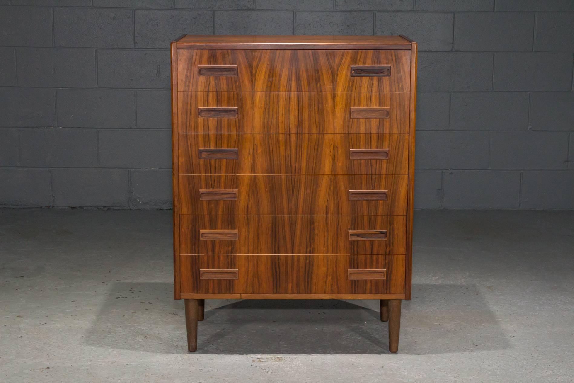 Danish Modern Rosewood Chest of Six Drawers on tapered legs. Beautiful rosewood grain, recessed pulls, and dovetail joinery.