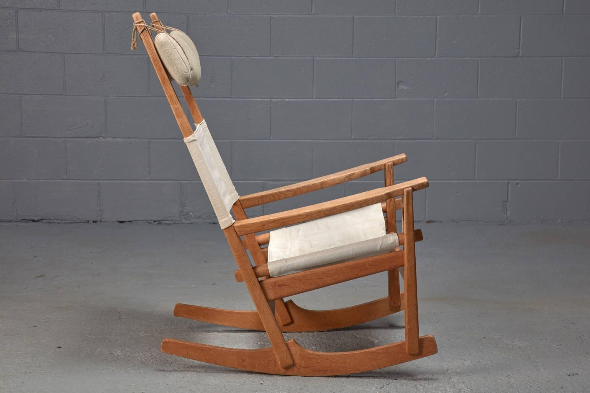 Designed by Hans Wegner, the keyhole rocking chair is easily distinguishable through oak frame and its keyhole-shaped joinery. The seat and back are made of woven fabric, and a head cushion is designated to provide additional comfort.