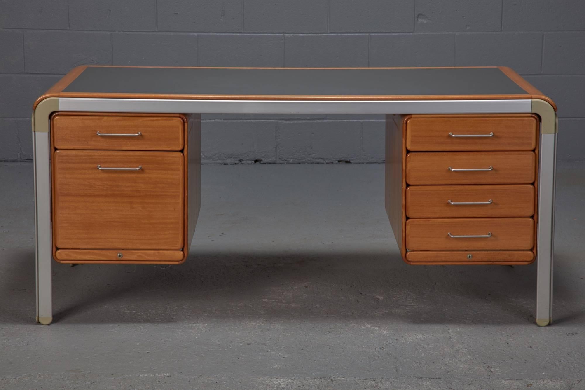 Danish architect Arne Jacobsen designed this Danish Modern desk in conjunction with his architectural design for the Danish National Bank, which was completed in 1970. The desk, made of pearwood, grey laminate and aluminum, contains six drawers and