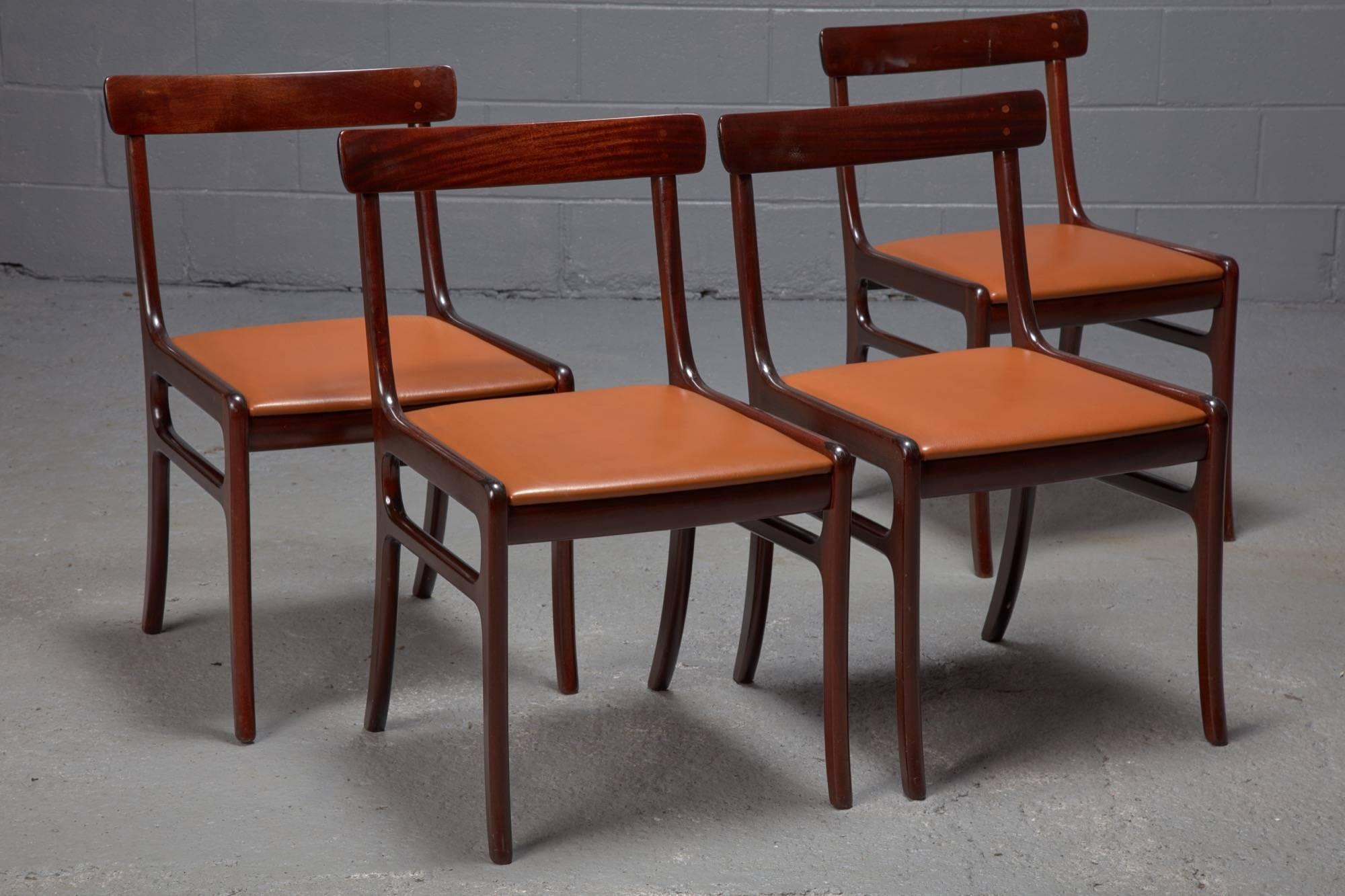 Designed by Ole Wanscher in the 1960s, this set of Rungstedlund dining chairs features a mahogany frame, a curved top rail for comfort, and a slightly reclined back. The seats are upholstered in cognac leather. Sold in set of four.