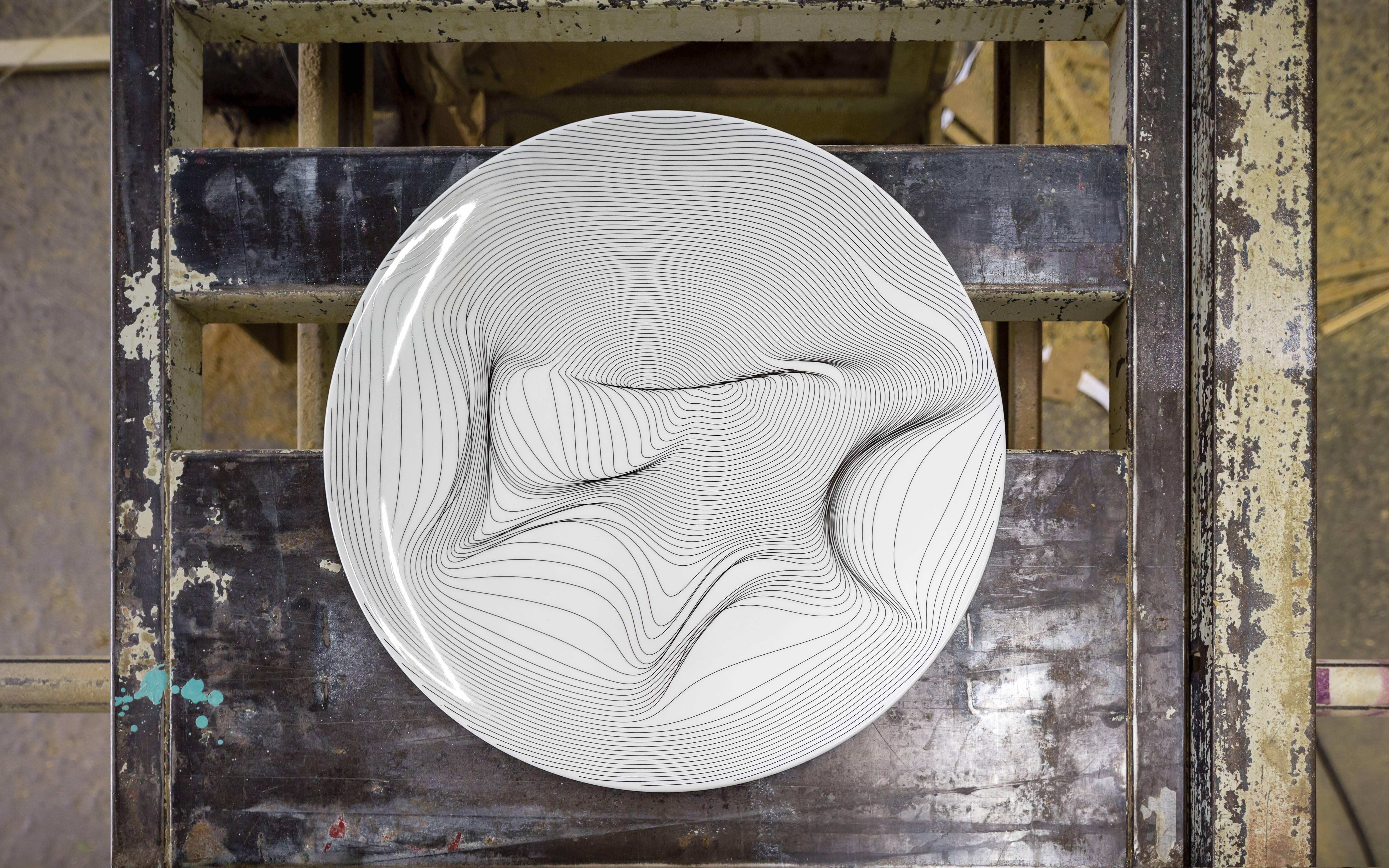 P.li is a platter whose drawing was developed through a parametric software and it is composed of concentric lines (a radial grid) and some points that either attract or repel these lines. The change in position of these points will alters the whole