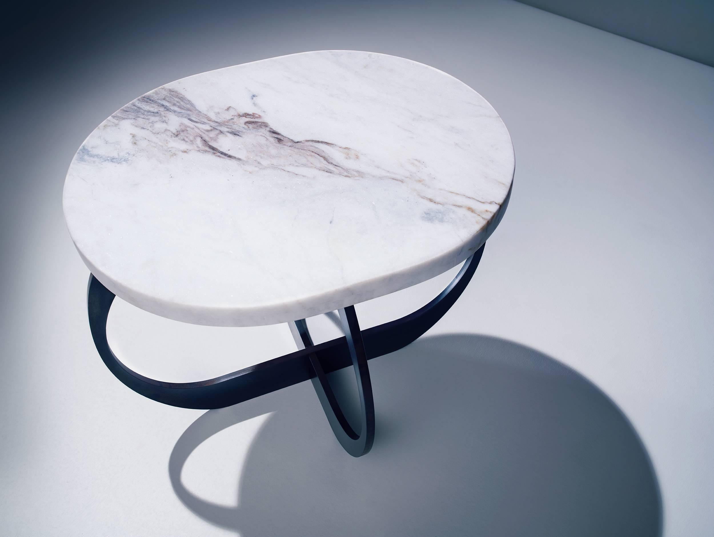 A smartly shaped side table that will be an instant style boost for your home.
The base is created from interlocking oval-shaped pieces of plate steel that fit together seamlessly.
Rare calacatta marble shines brightly against the deep blackened