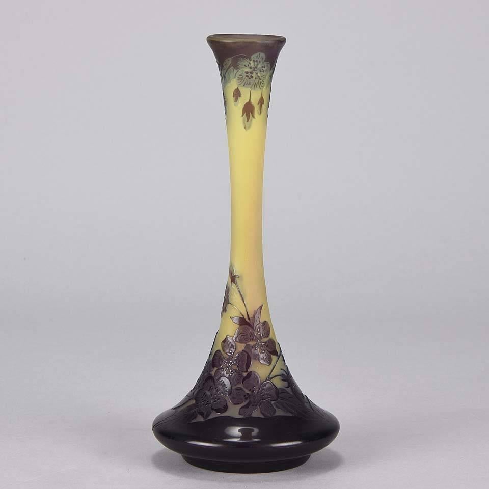 A very pretty late 19th century cameo glass vase of slender form etched and acid cut with a variegated purple Art Nouveau floral decoration of hanging flowers on a yellow field, signed Gallé.