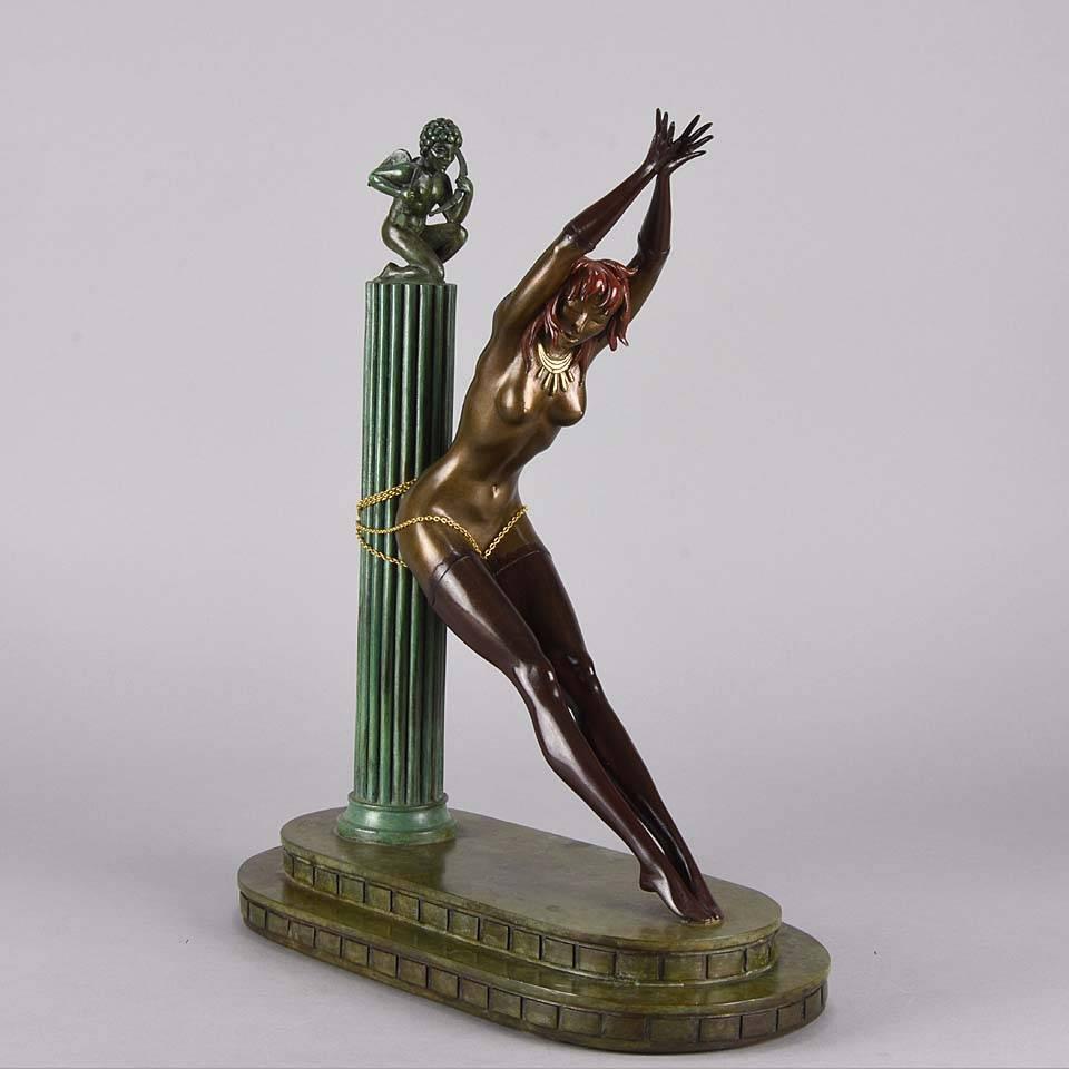 A fabulous 20th century Art Deco bronze figural group entitled ‘Prisoner of Love’ by Erté, Romain de Tirtoff – modelled as a beautiful young woman in long stockings chained to a classical column overlooked by a kneeling figure of cupid with bow and