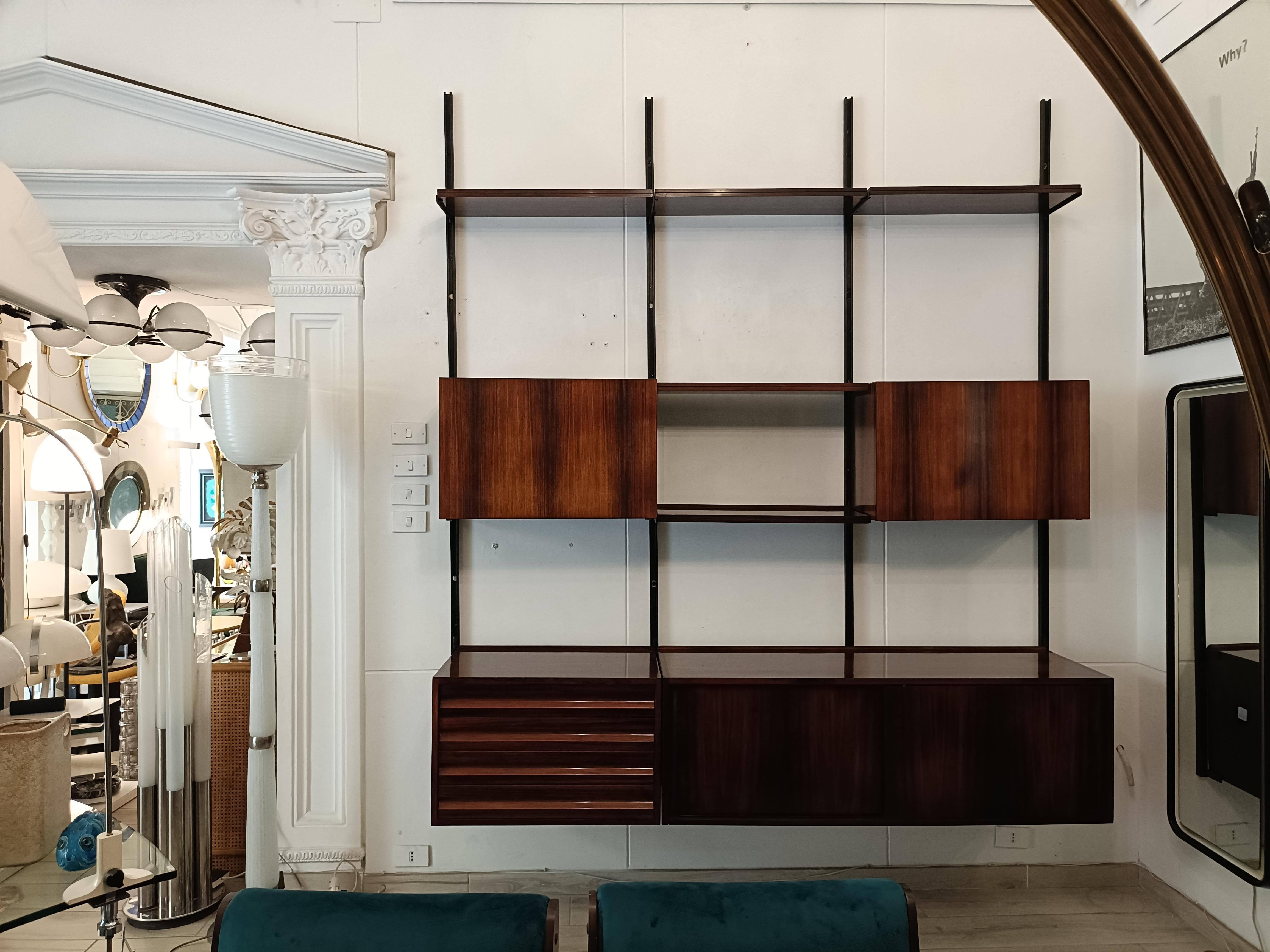 Libreria modello E22 prodotta da Tecno negli anni ’60 su progetto di Osvaldo Borsani.
Montanti in alluminio verniciato nero.
Due moduli contenitori e 5 mensole in legno impiallacciato, un 
modulo con 2 ante scorrevoli e un modulo con 4