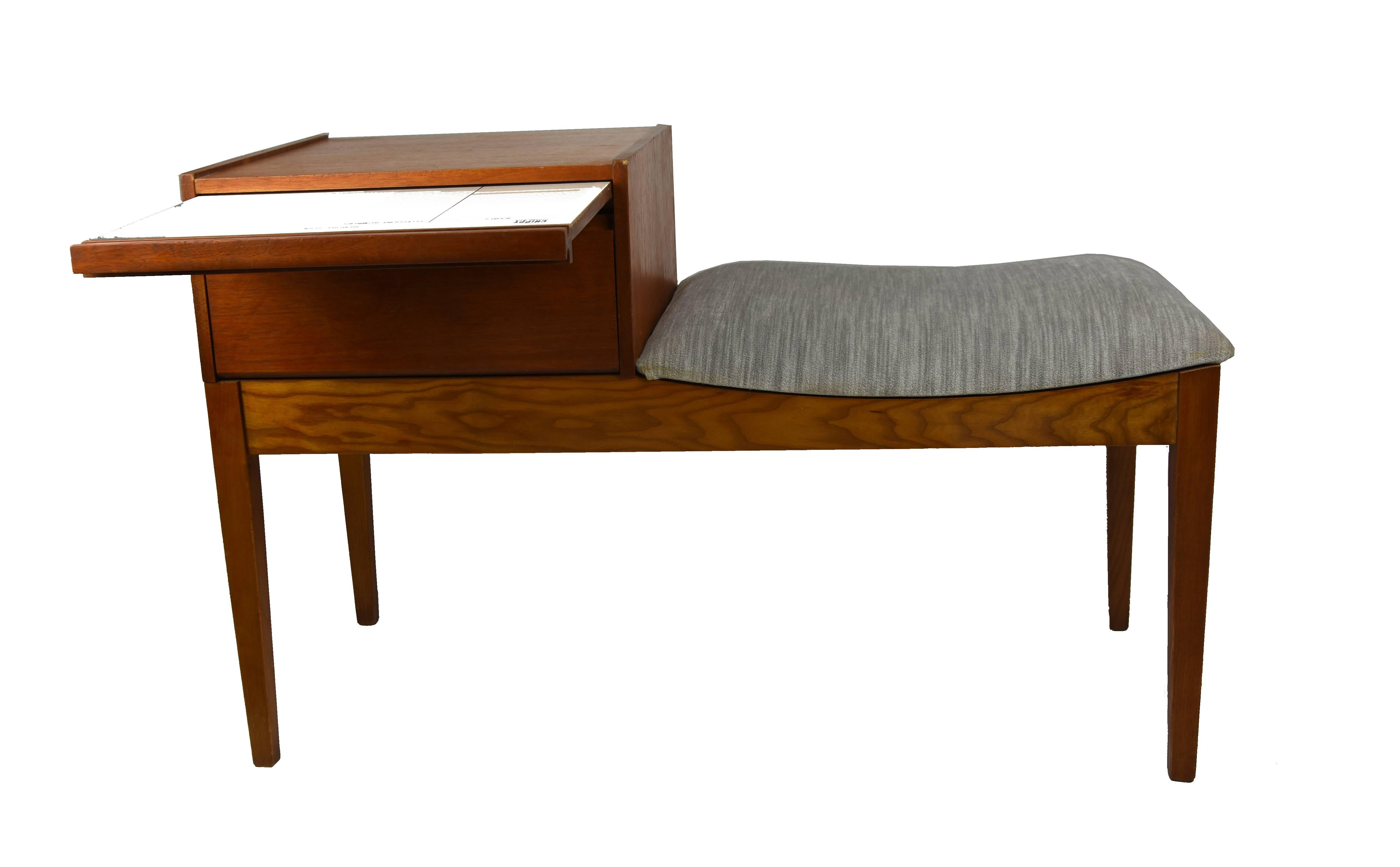 A unique and very well made telephone bench in teak, this was made by Chippy Heath and it dates from the 1960s-1970s. The condition is superb for its age, the grey crush velvet fabric upholstery is new, the frame is nicely polished, sturdy and