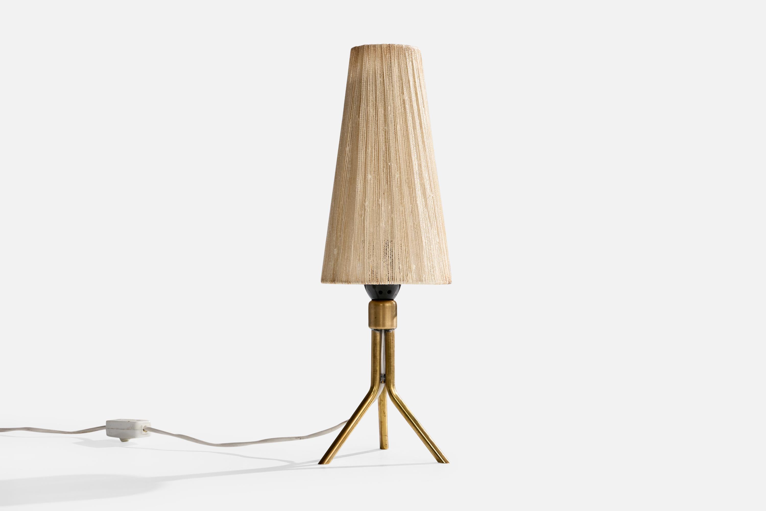 A brass and light beige fabric string table lamp designed and produced in Sweden, c. 1950s.

Oxidation present to brass

Wear to vintage shade consistent with age and use

Overall Dimensions (inches): 16.5