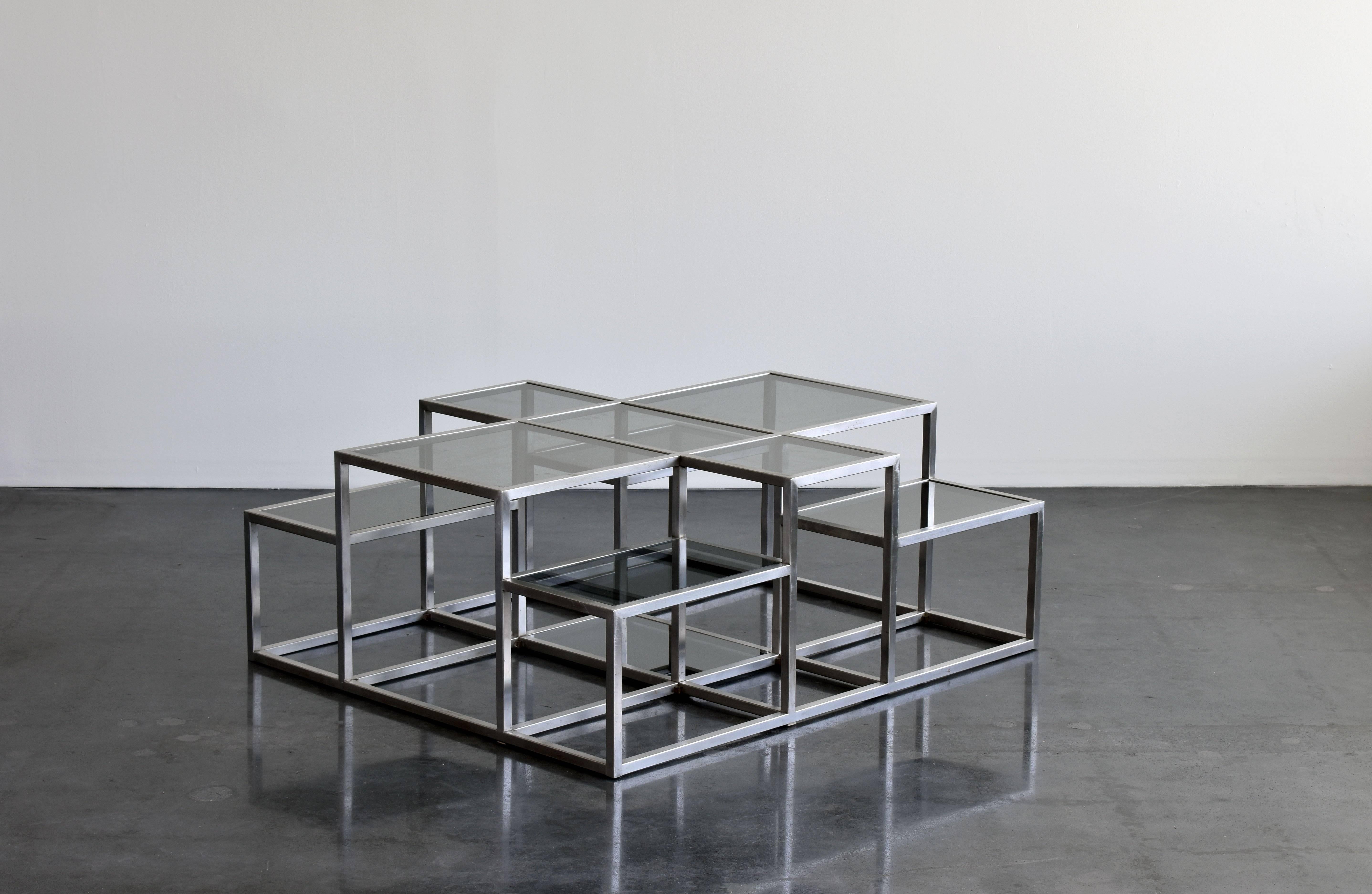 A large sculptural, minimalist coffee table by Michel Boyer in stainless steel with smoked glass plates. The form bears similarity to minimalist works, such as those by Sol Lewitt. 

Michel Boyer is one of many important designers working in metal.