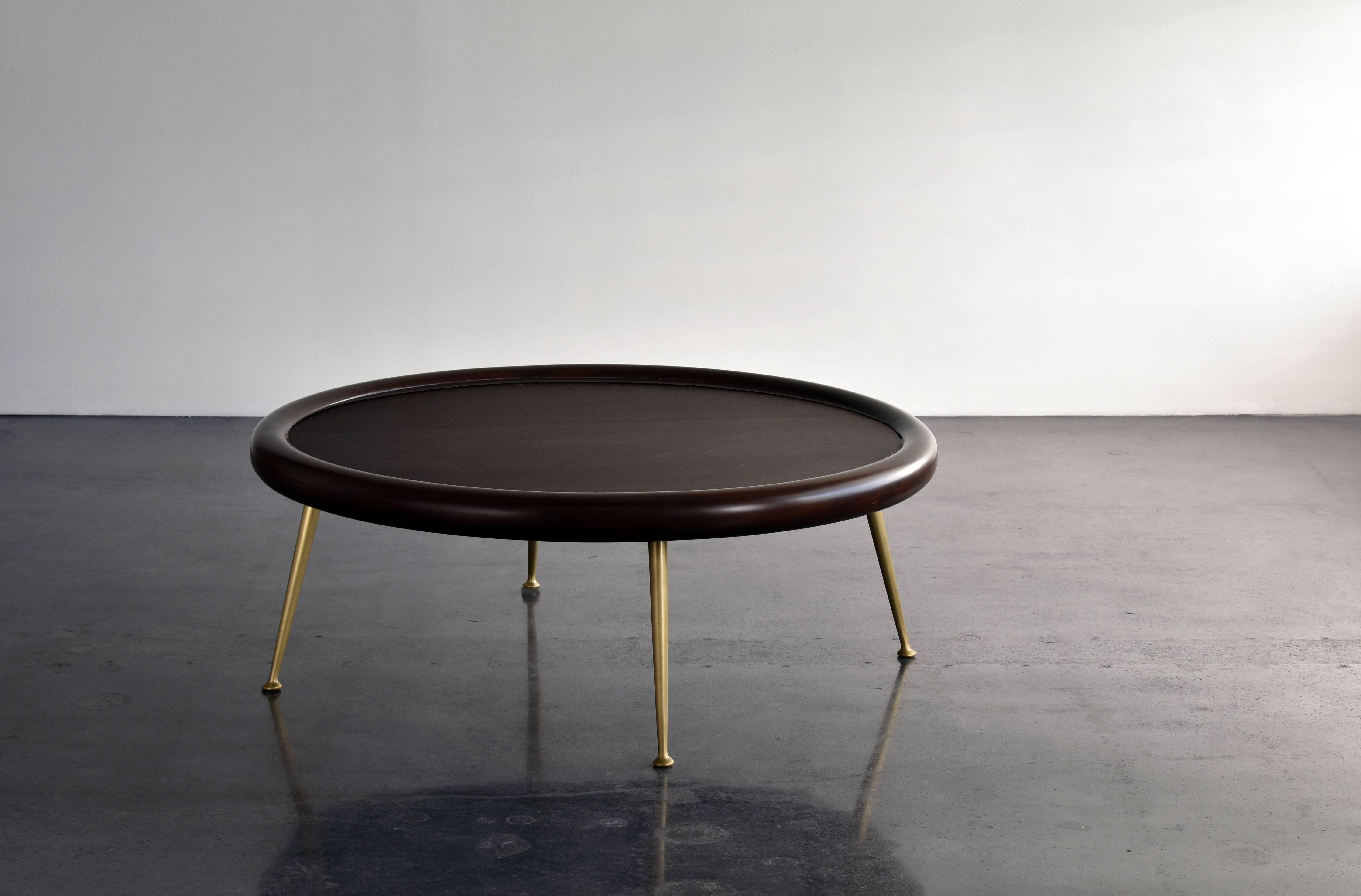A modern coffee table partly lending it's aesthetics from ancient Grecian design. This theme being the hallmark of how the architect and furniture designer T.H. Robsjohn-Gibbings executed his designs. 

The dark-stained walnut top provides a
