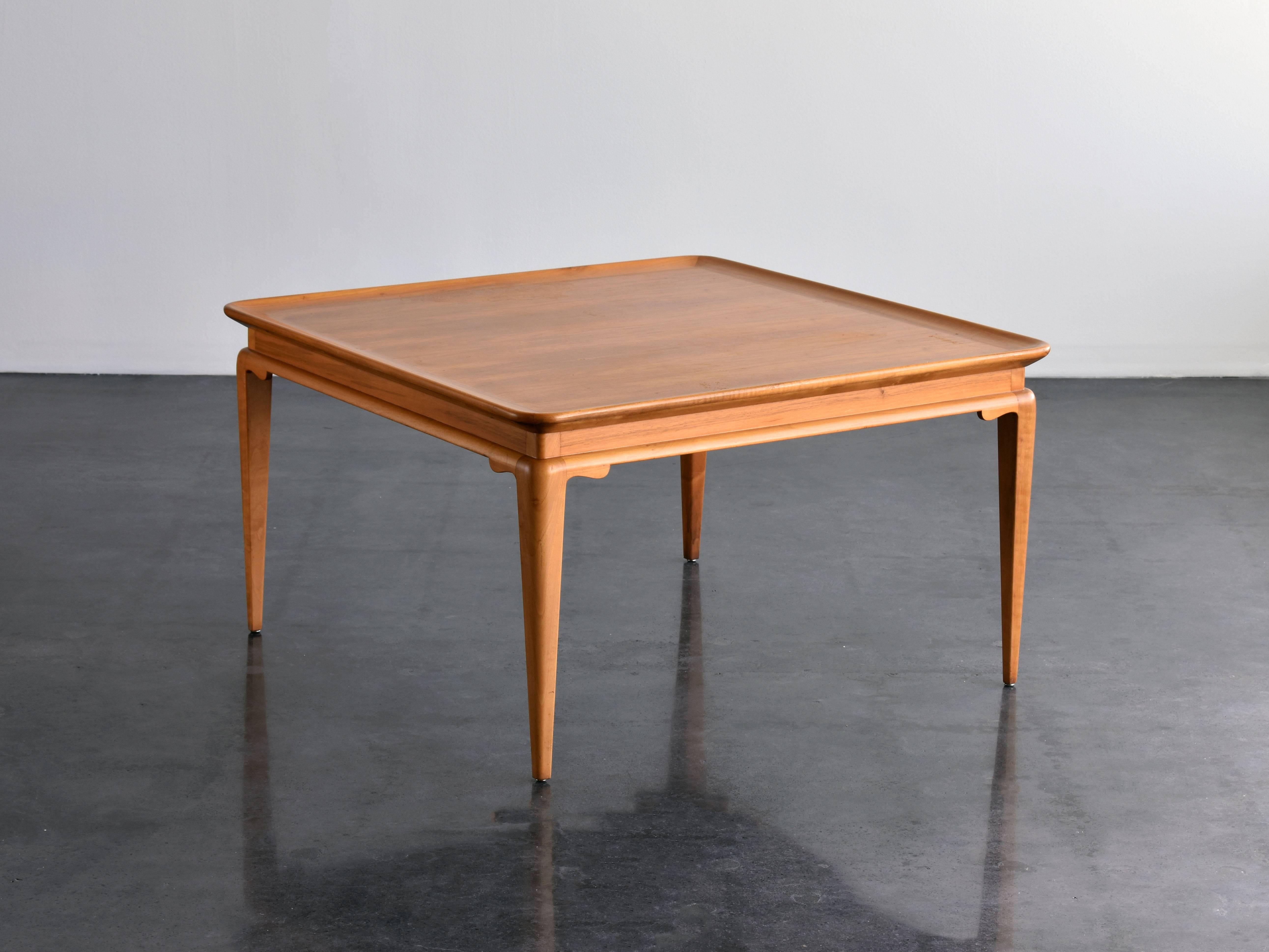 Coffee table or cocktail table in light walnut produced by Ditzingers, Sweden, 1930s. Square shaped top with raised edges. Supported by four legs bearing modern ornamentation.
