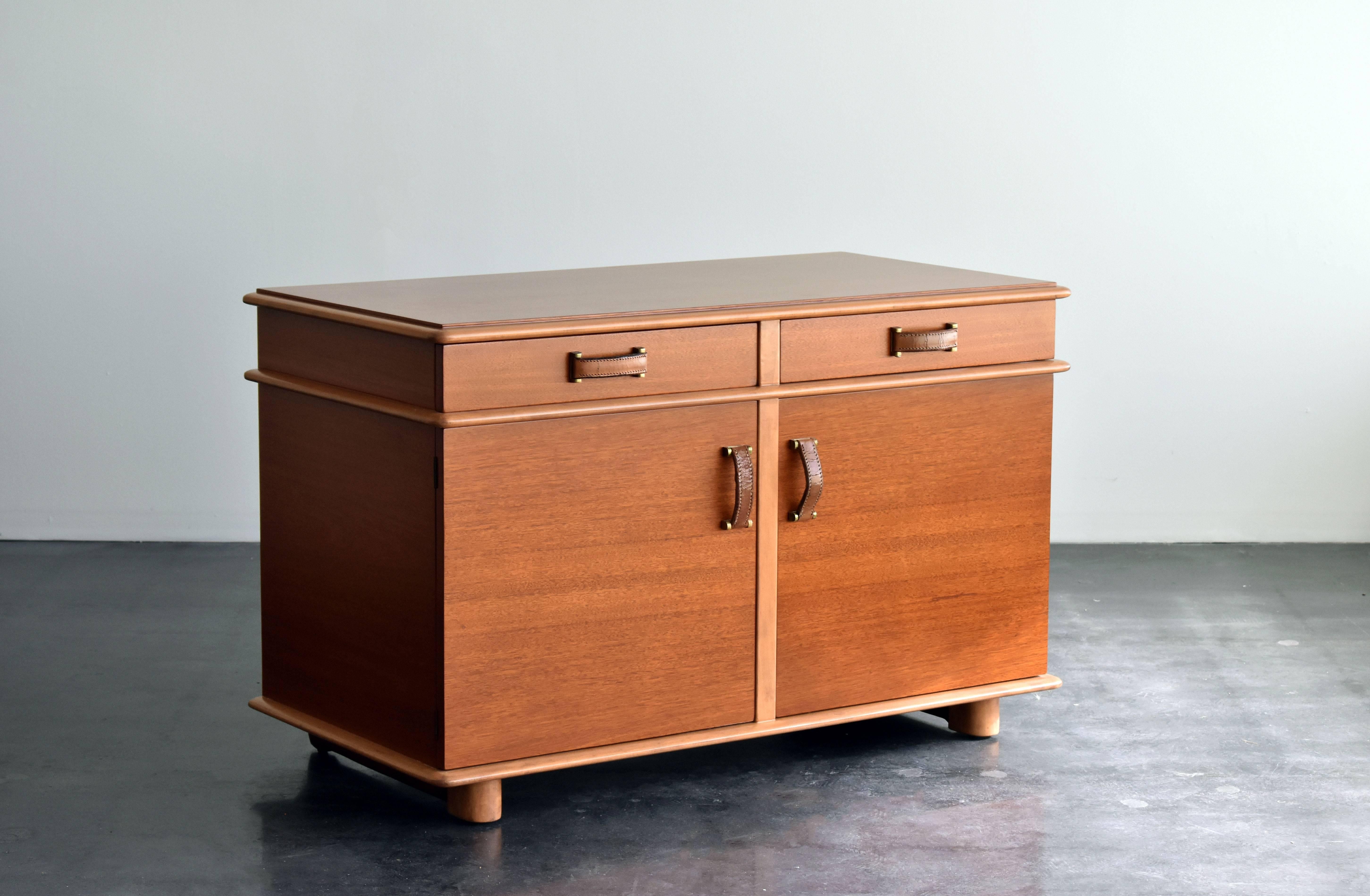 A beautiful and practical cabinet or buffet executed in mahogany, birch, leather, maple, brass. Features practical storage and a bar section.

Bears the iconic design of Austrian modernist designer or architect Paul Frankl. The present example is