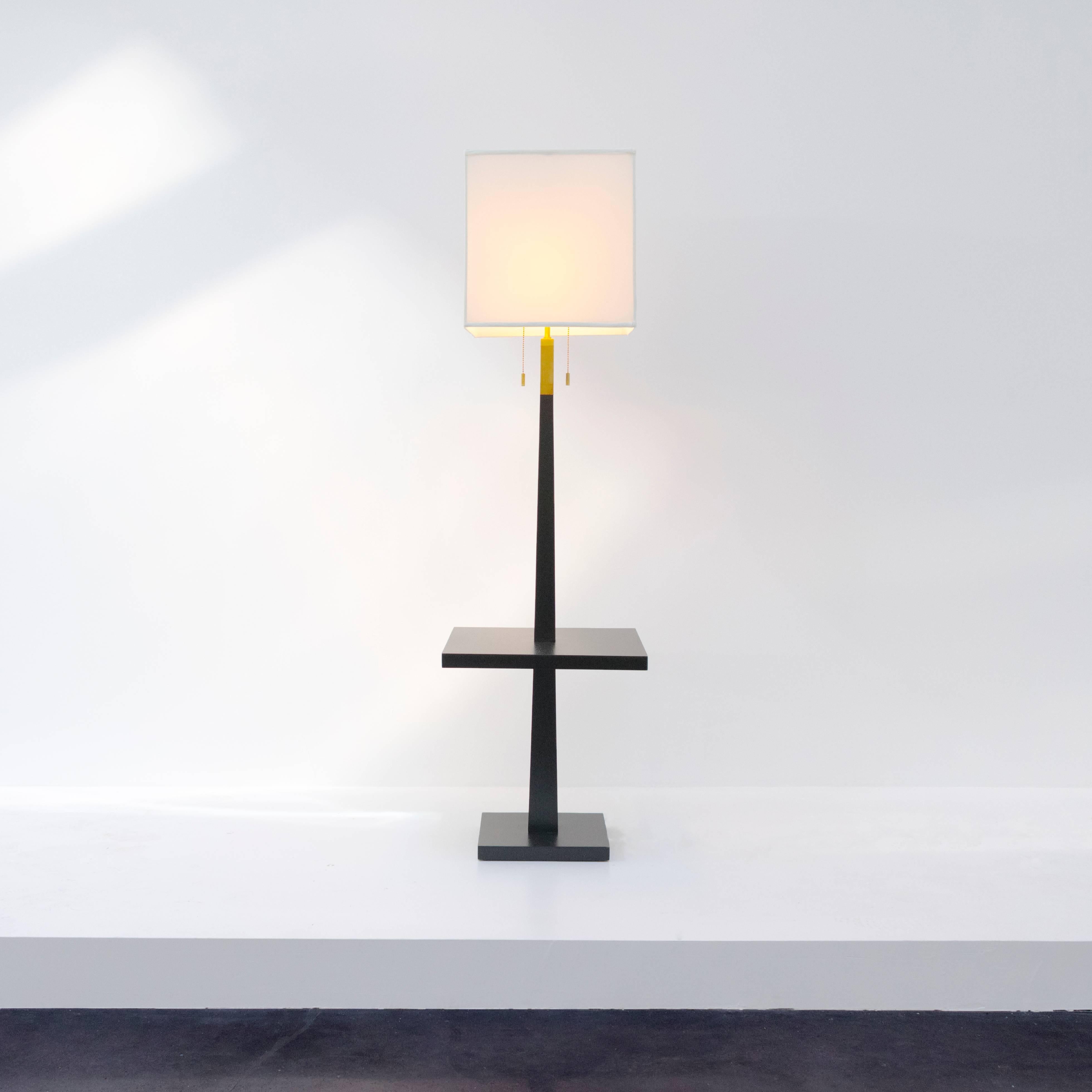 An elegant and practical floor/table lamp with a Minimalist expression. Black stained wood, brass details, white screen with square form. American, 1960s. Three-light sources.