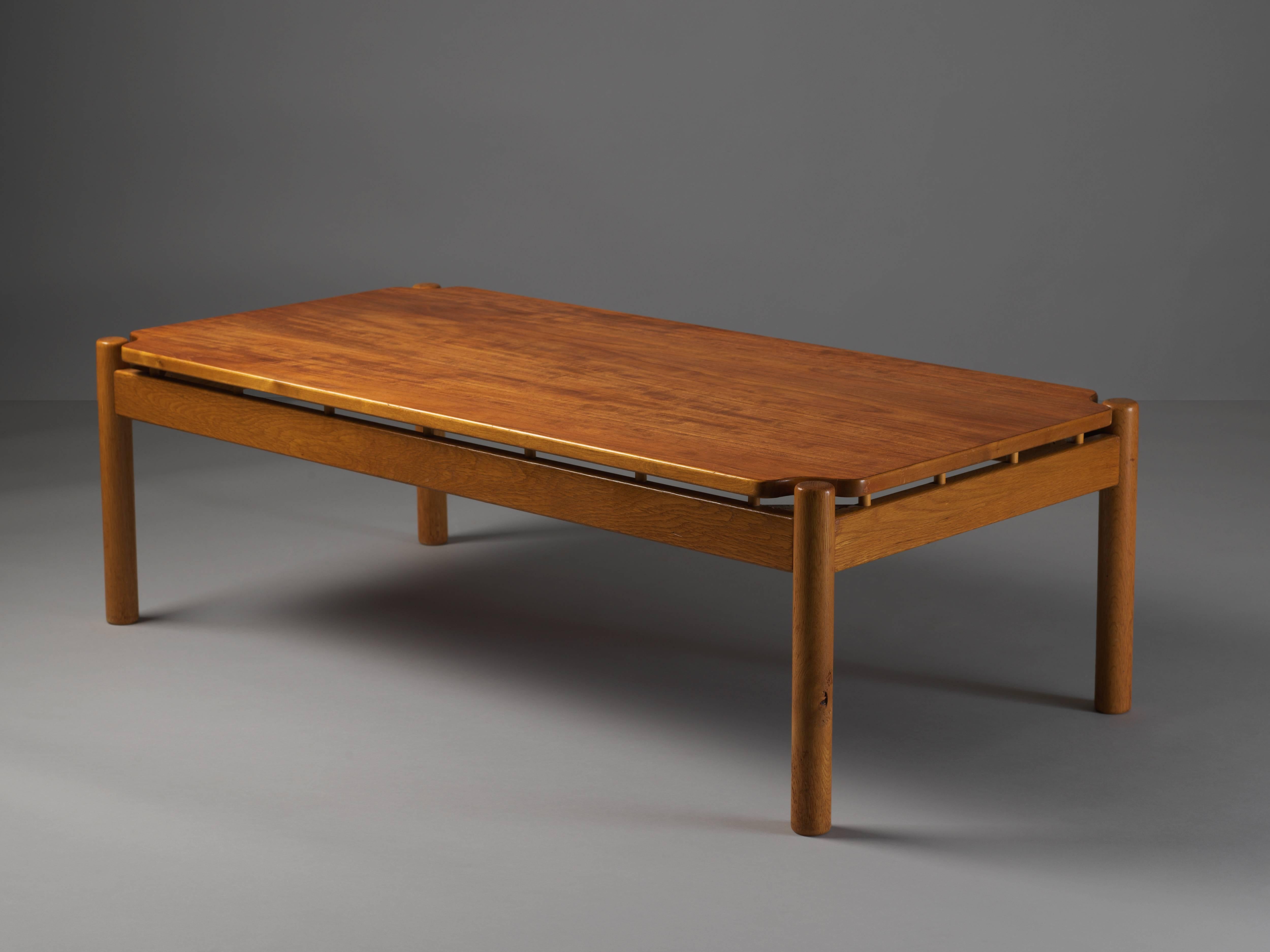 A low Mid-Century Modern coffee table designed in 1959 by Finnish architect and designer Ilmari Tapiovaara for Swedish company Edsbyverken. Teak top mounted on an oak base. Original condition. 

At one point a disciple of Le Corbusier, this rare