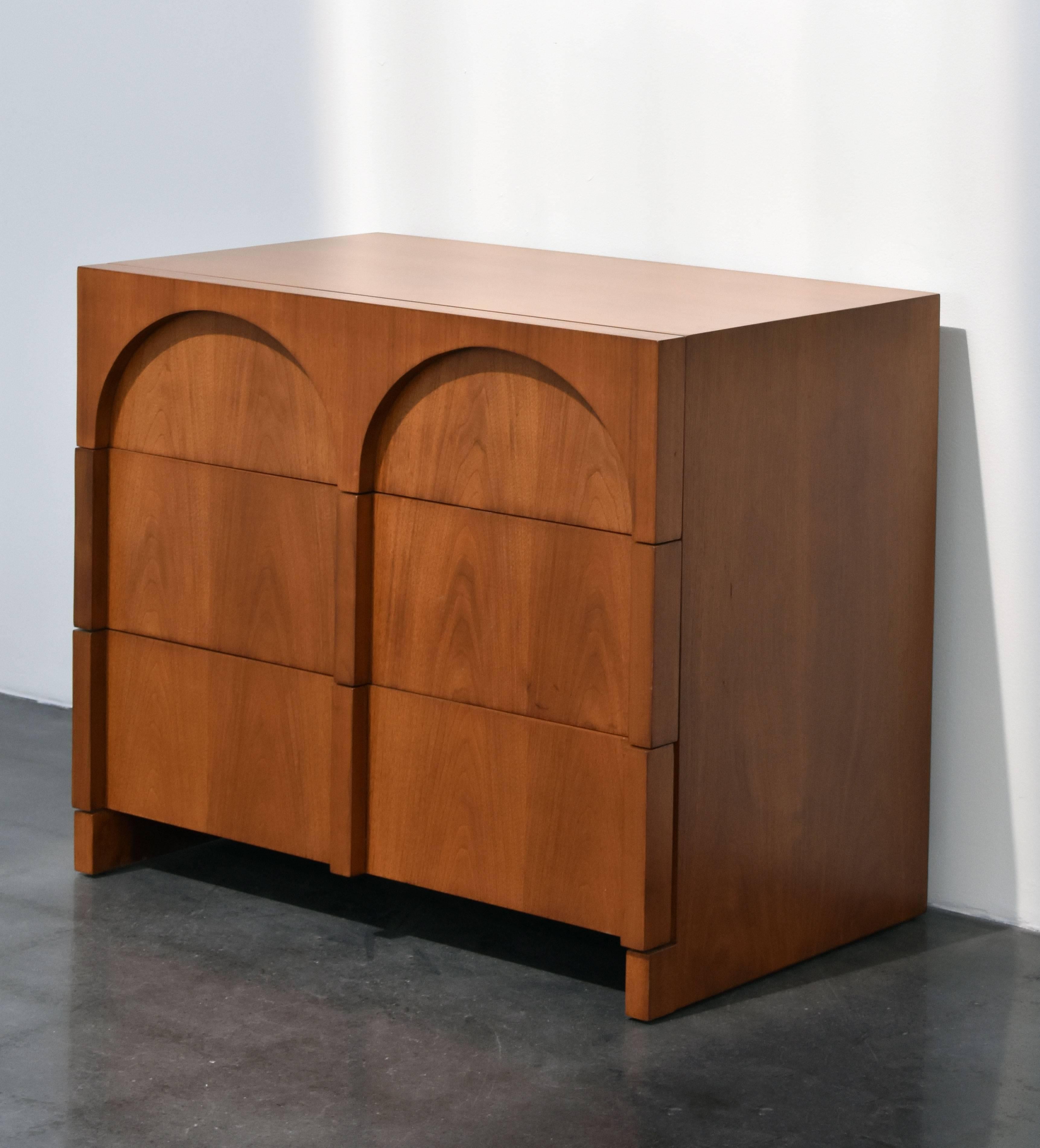 American design Colosseum walnut dresser, cabinet or chest of drawers. Produced by Widdicomb Furniture Company and designed by T.H. Robsjohn-Gibbings.

The stylized front mixes arches resembling ancient architecture with a very modern appeal.