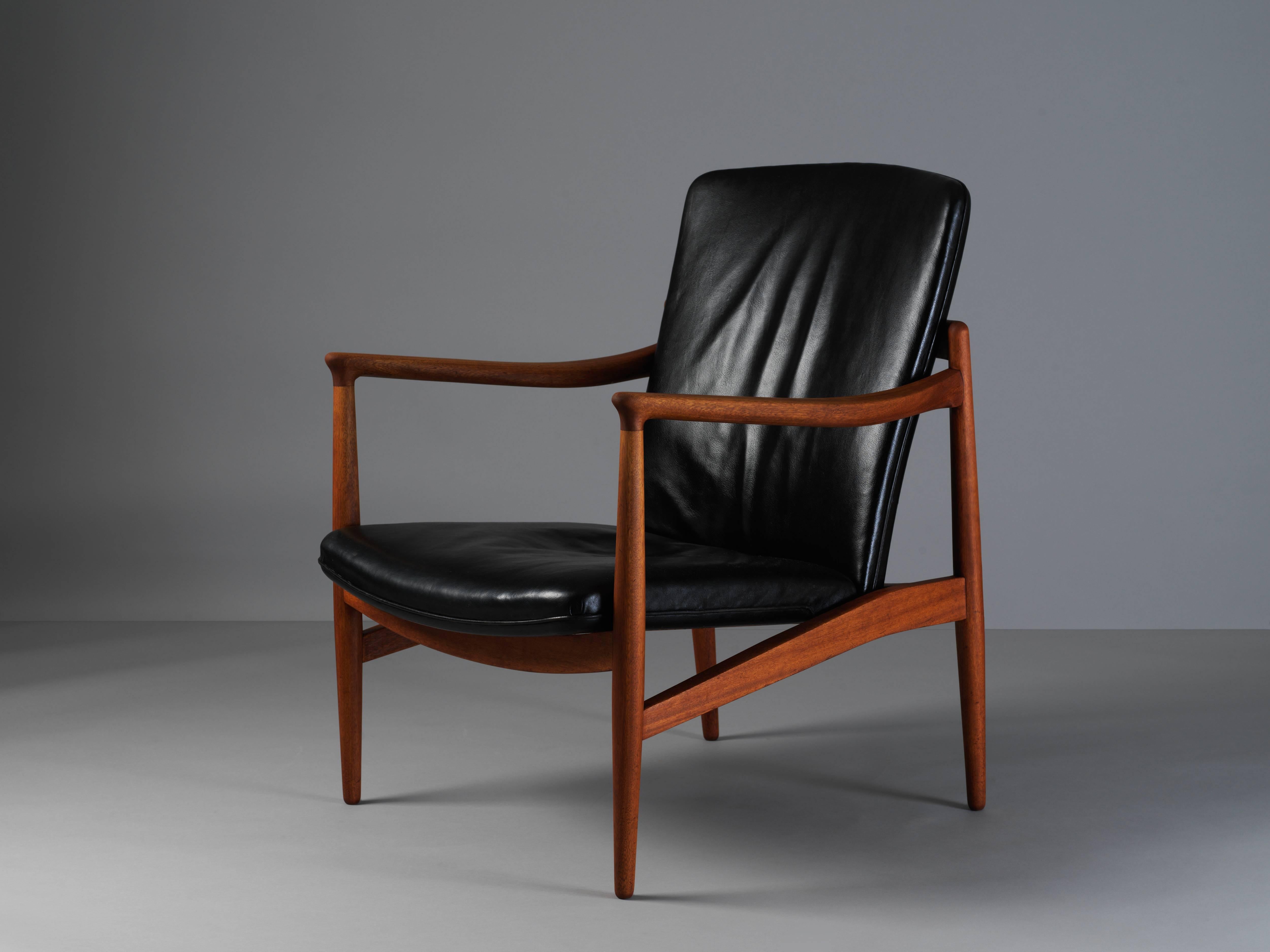 A lounge chair by Danish cabinet maker and modernist pioneer, Jacob Kjaer, designed in 1945. Handmade in teak and original black dyed leather. Carries manufacturer's label.

Jacob Kjaer also executed furniture designs for other creators such as