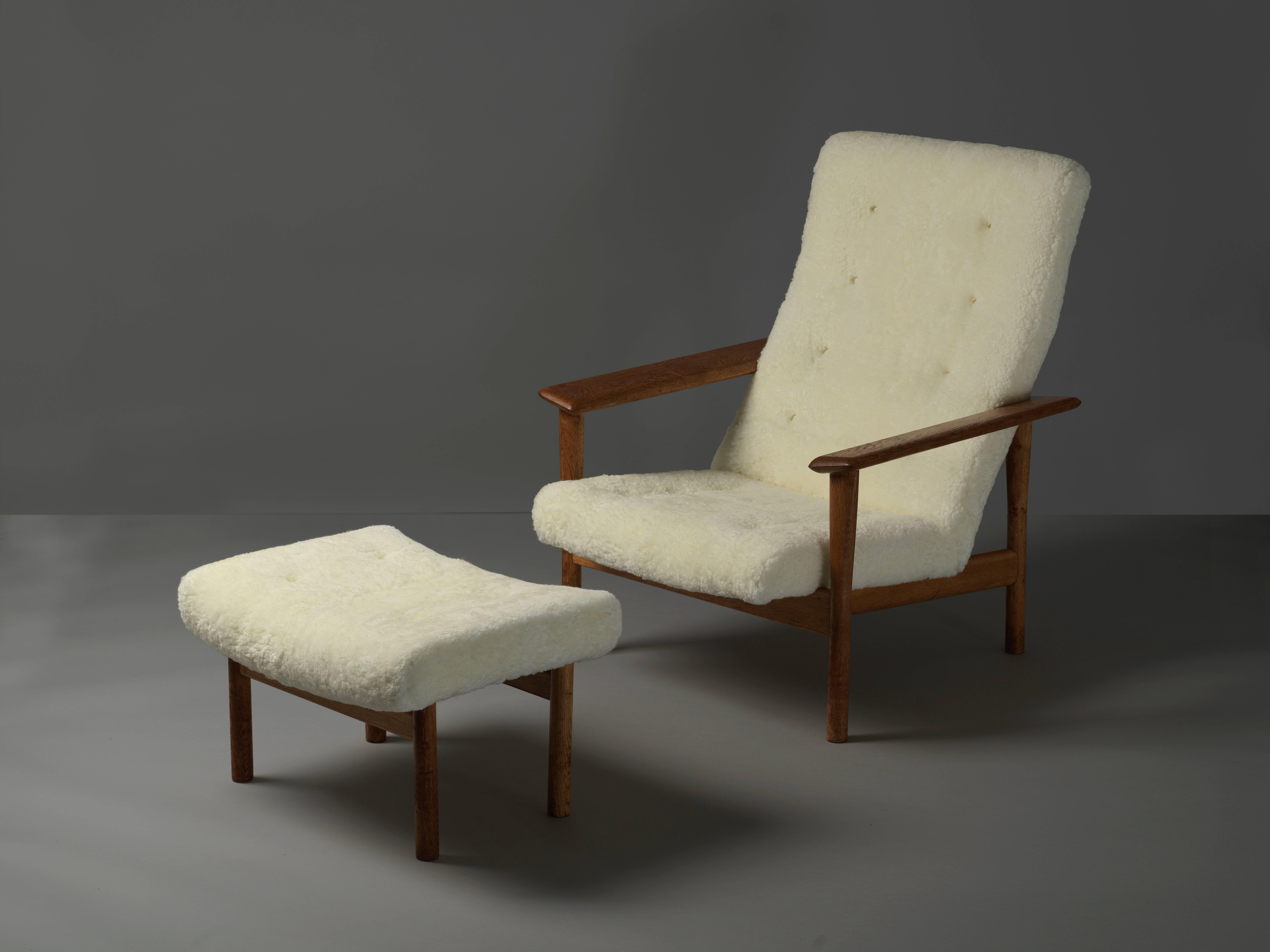 A Danish high back lounge chair with ottoman designed by Ejner Larsen & Axel Bender Madsen. Executed by cabinetmaker Willy Beck, Denmark and marked with a metal label. Upholstered in lambskin. 

Designed in 1961 and prominently displayed in the