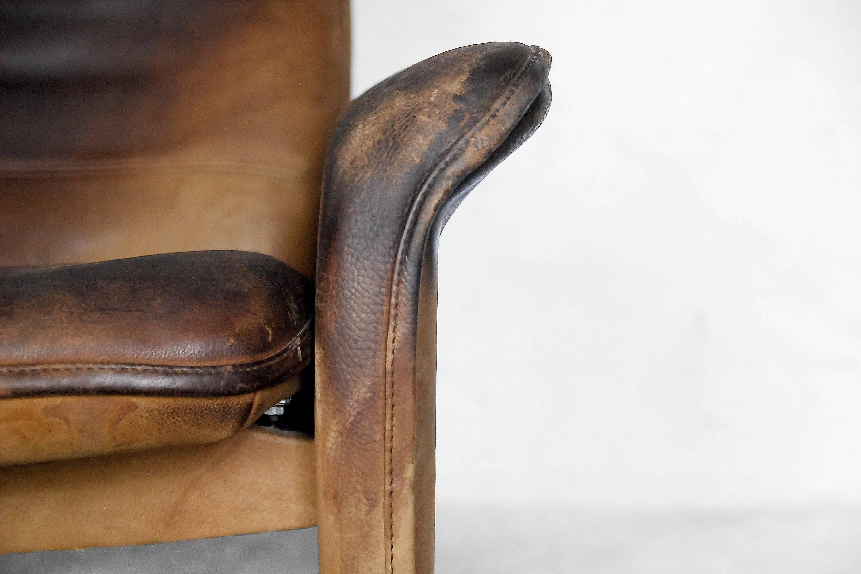 This vintage lounge armchair was manufactured in Switzerland by De Sede, during the 1970s, and is a model DS-50. De Sede is renowned worldwide for quality leather furniture making, and this piece is upholstered in thick brown leather with hand