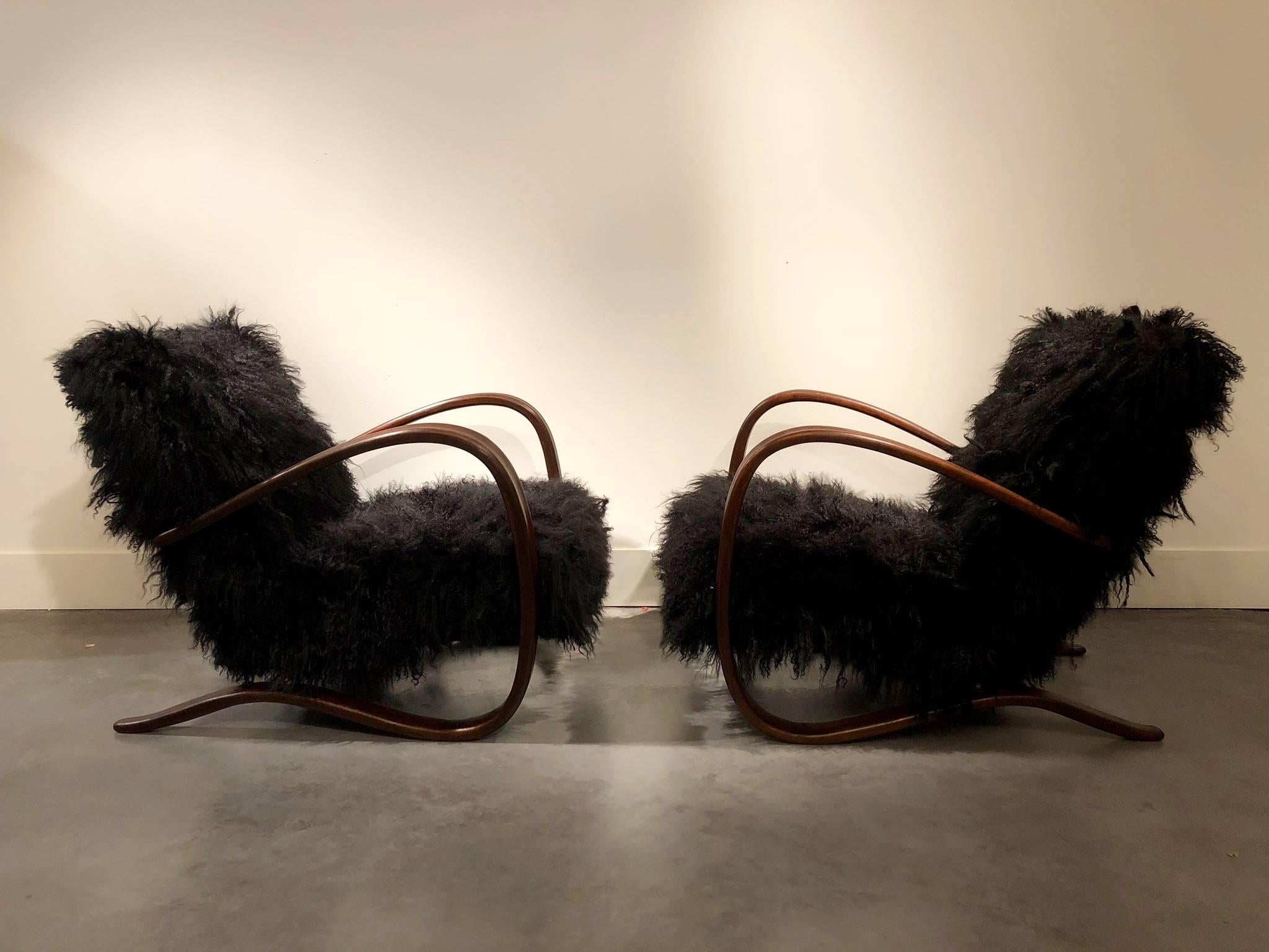 Pair of midcentury lounge chairs by the Czech designer Jindrich Halabala (1903-1978) completely refurbished and reupholstered with black sheepskin.
Designed during the 1930s, these armchairs are still astonishingly modern.
 