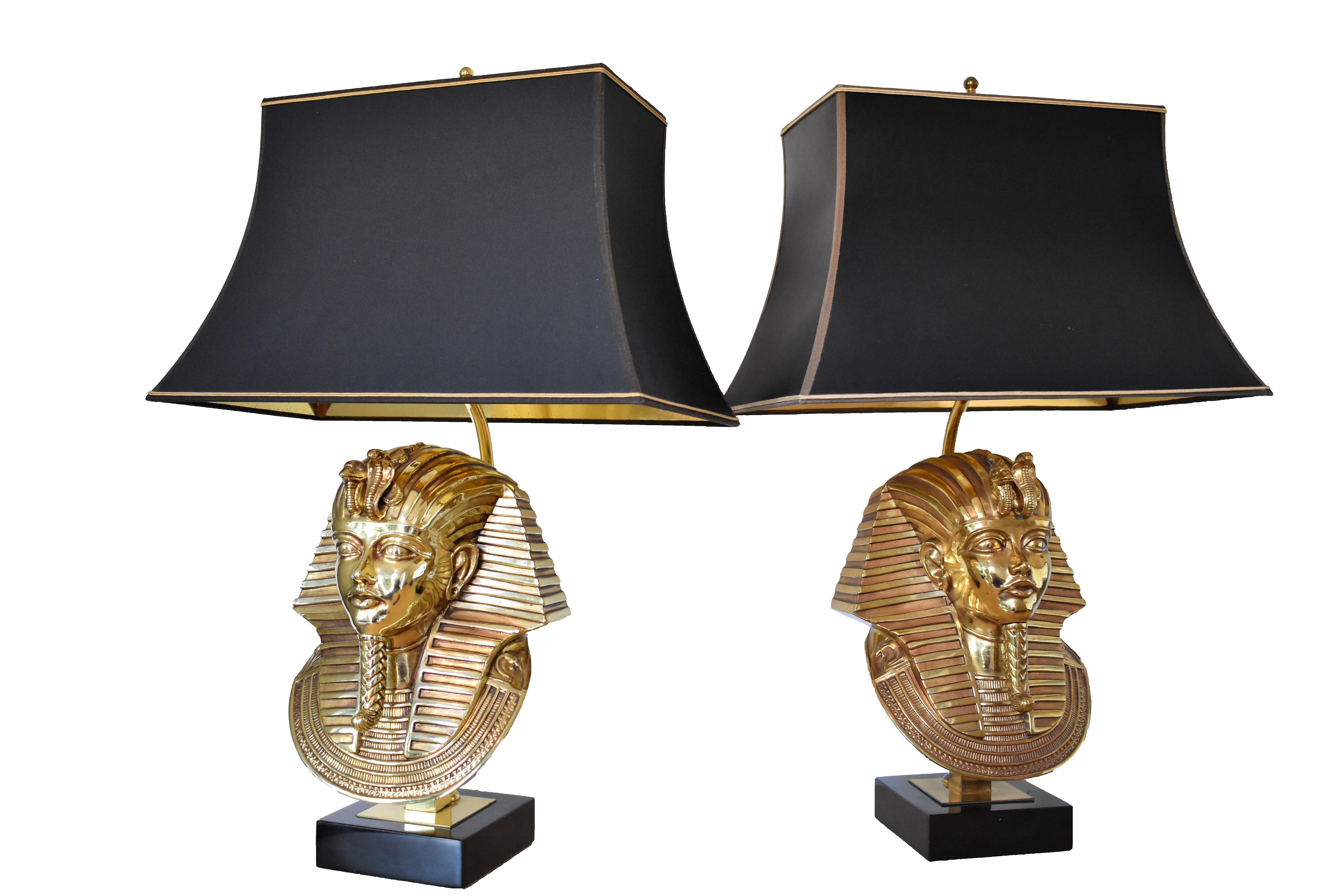 These impressive and luxurious pharaoh head table lamps are made from brass and plated with 24-karat gold. They are mounted on a black marble base and have original dark grey and gold lampshades.

Each table lamp has room for three bulbs (two large