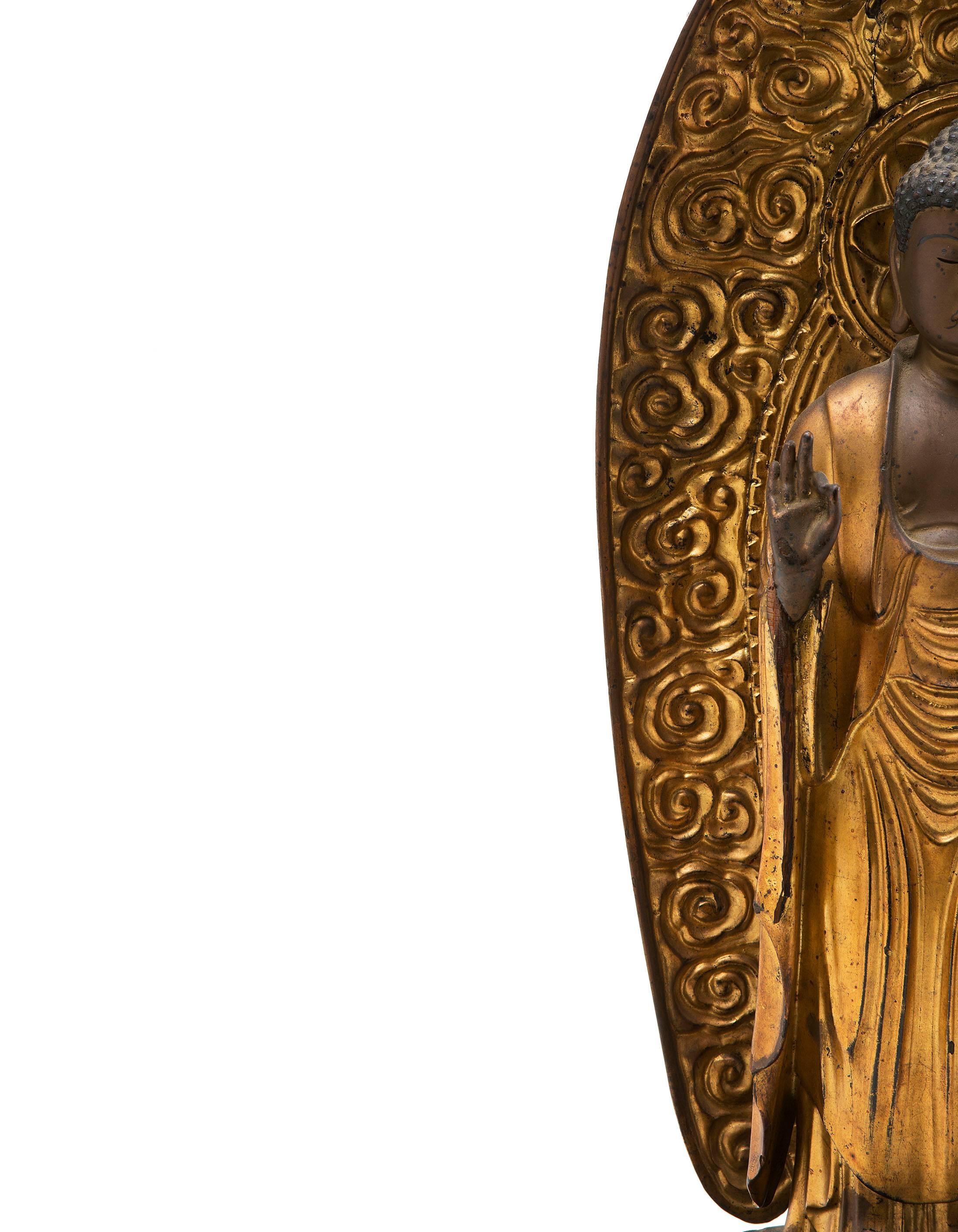 Japan, Edo period (1615-1868), 18th century
Measure: High 63 cm, long 26 cm.

Carved Gilded Wood Standing Amida Buddha. In gold lacquered wood representing the Buddha standing on a lotus posed on a hexagonal base with several worked levels, both