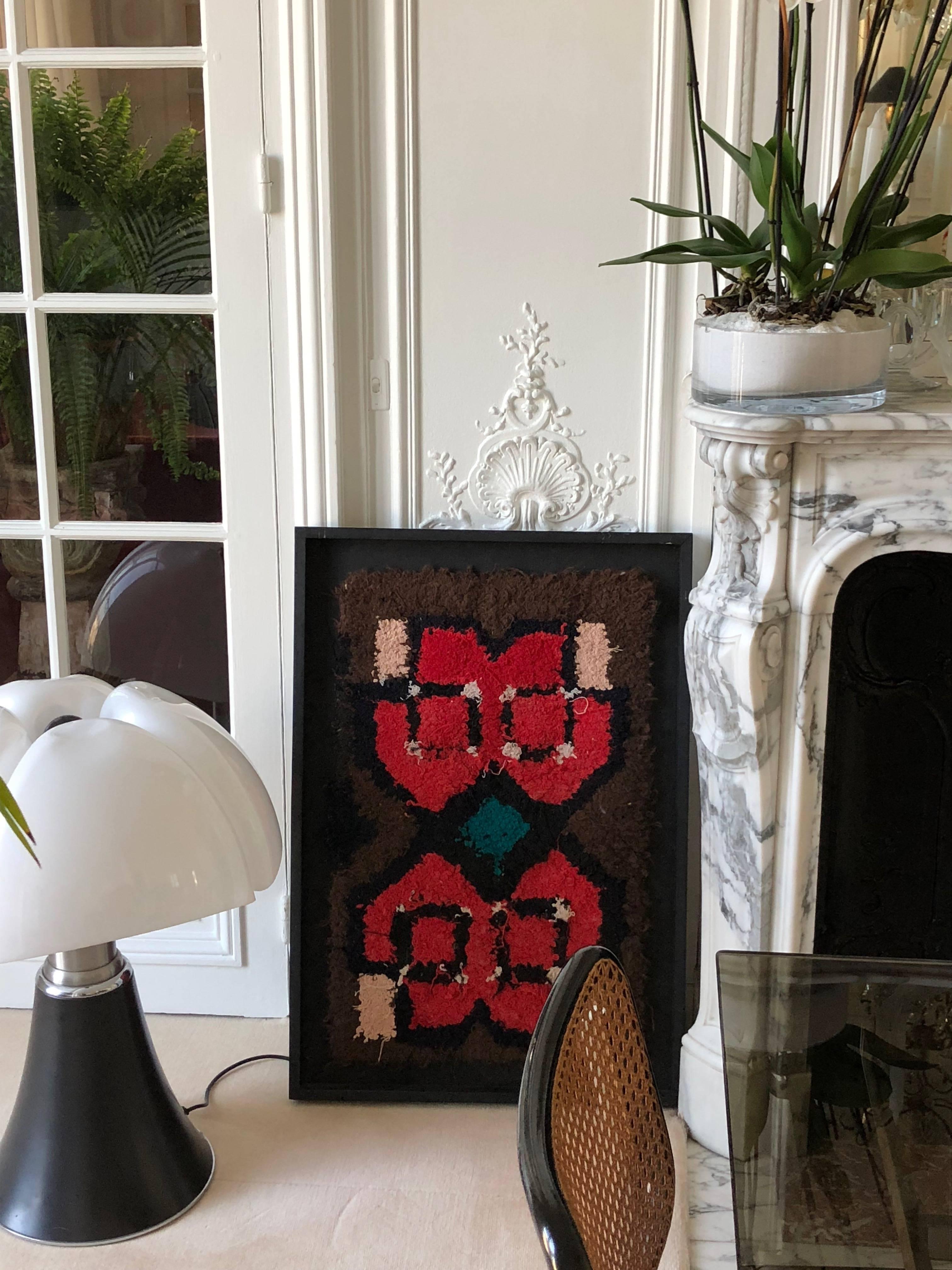 Berber tribal artwork handmade by women of the Atlas Mountains originally for domestic use, this tapestry finds its expression with iconic symbols. 

The dimensions are width 58 cm x height 85 cm (frame included).

Zindekh tapestries are the