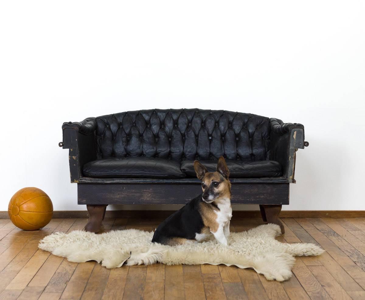 This small leather sofa  is a unique object. The mini sofa is over a 100 years old and used to serve as the drivers chair on a carriage. After removal, it has been placed on cast iron legs.

Underneath the seating, there is a build-in storage space.