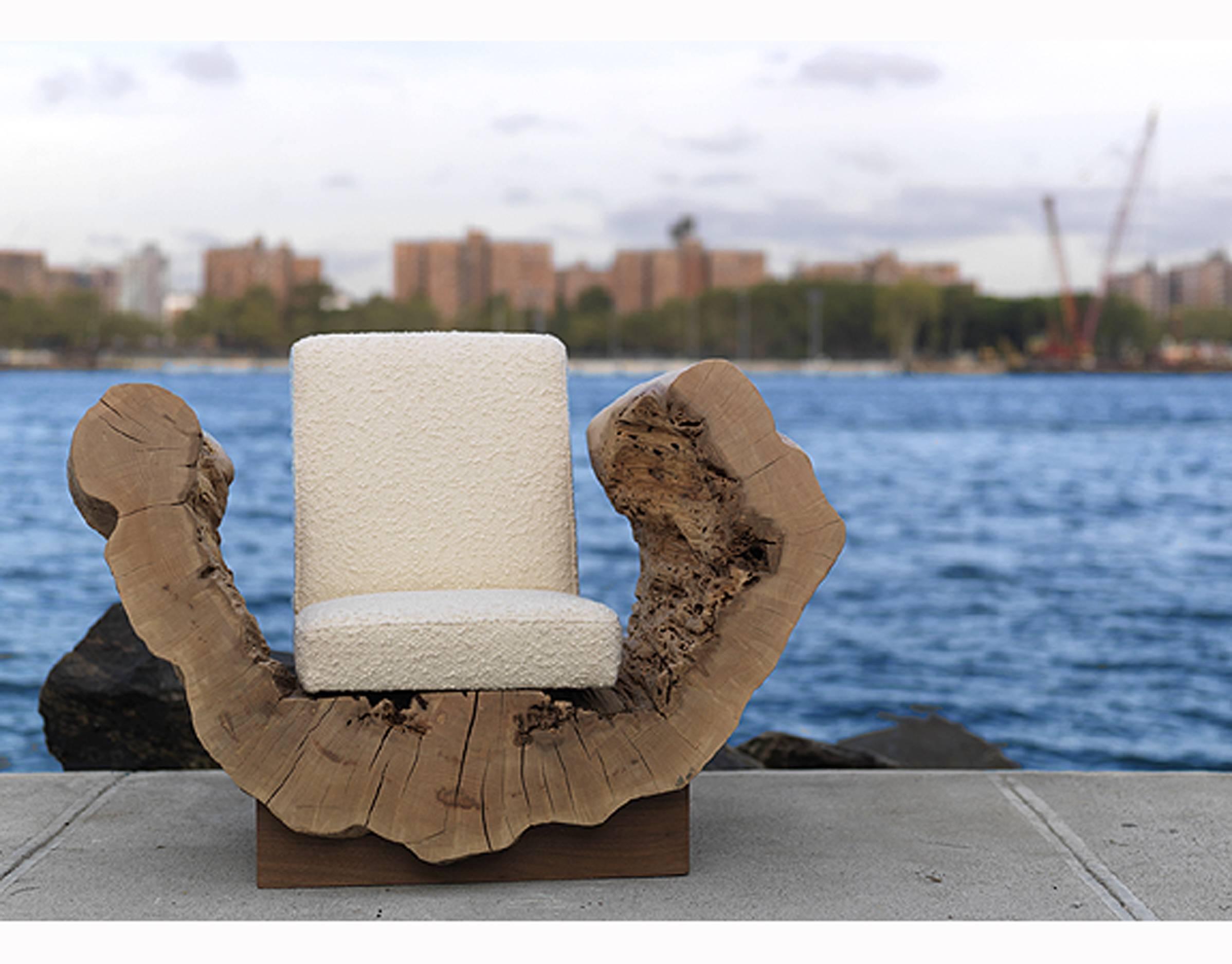 The organic, arching form of the reclaimed hardwood cradles a lightly positioned upholstered seat. The cocoon chair is a piece of sculpture which maintains its principal function: seating. Incredibly unique, the chair is suitable for residential and