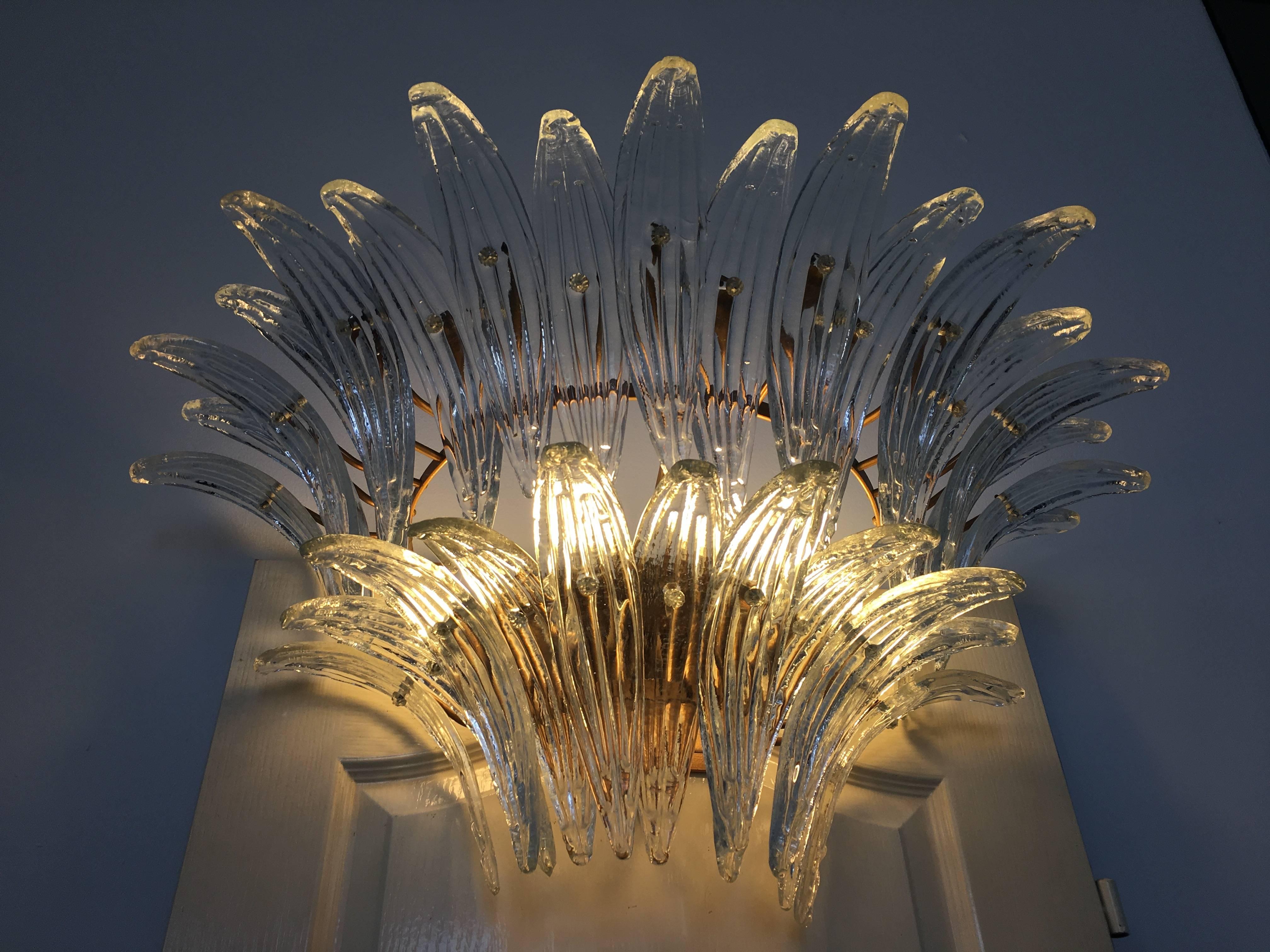 The sconces and chandeliers were located in the hall of a big hotel on the Amalfi Coast. Each individual sconce is composed by 29 large leaves in pure Murano glass. Available two pairs of sconces and original chandelier.