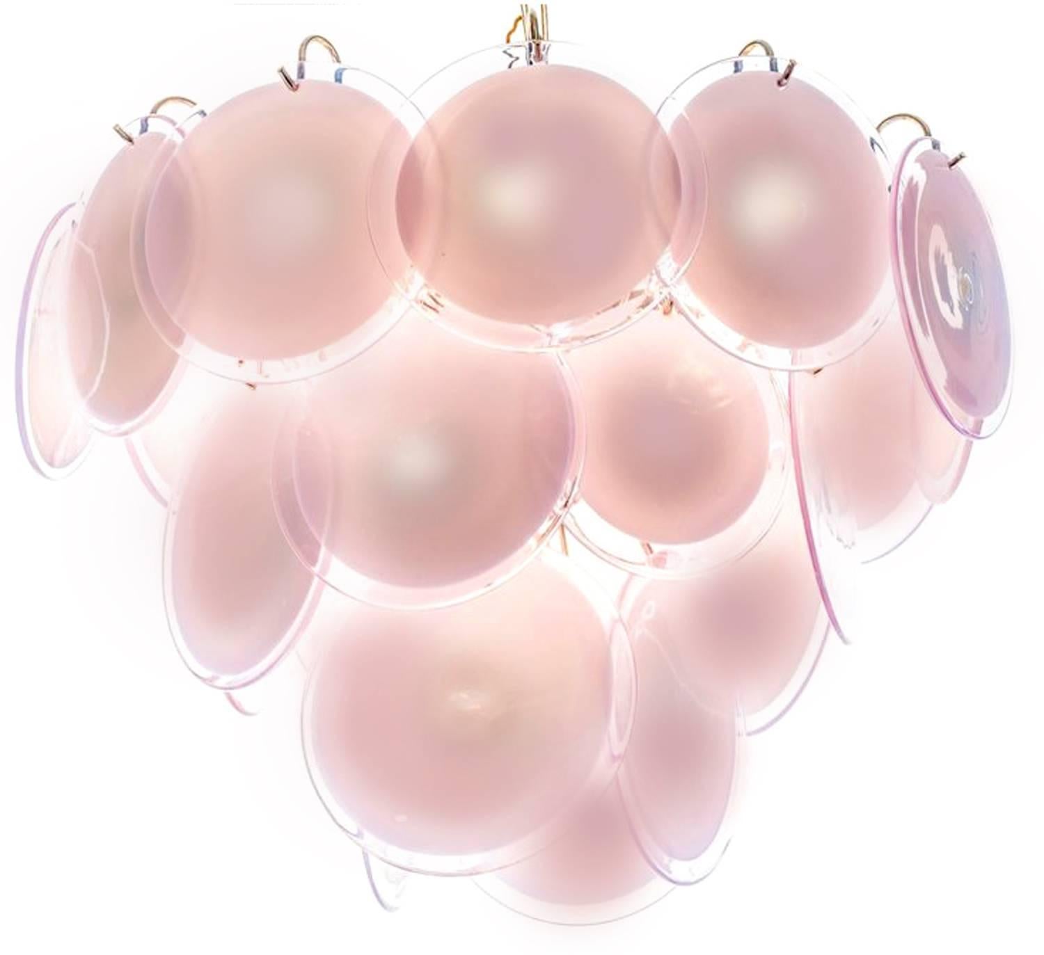 Spectacular pair of chandeliers by Vistosi made in Murano. Each chandelier is formed by 24 pink discs of precious Murano glass are arranged on floor levels. Nine lights. Measures: Height without chain 50 cm. Available also with white discs.
 