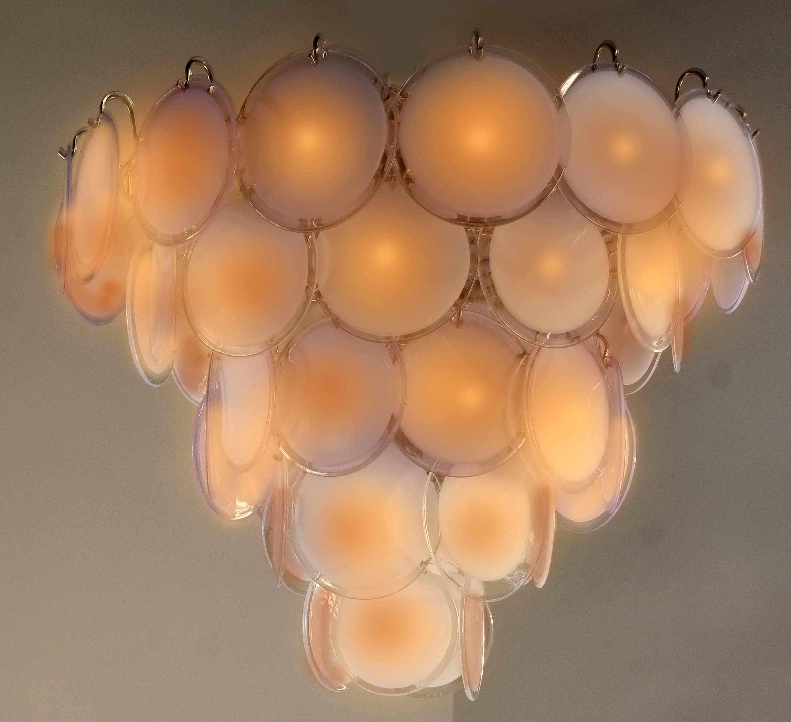 Spectacular pair of chandeliers by Vistosi made of 50 Murano discs honey color put on five floors.