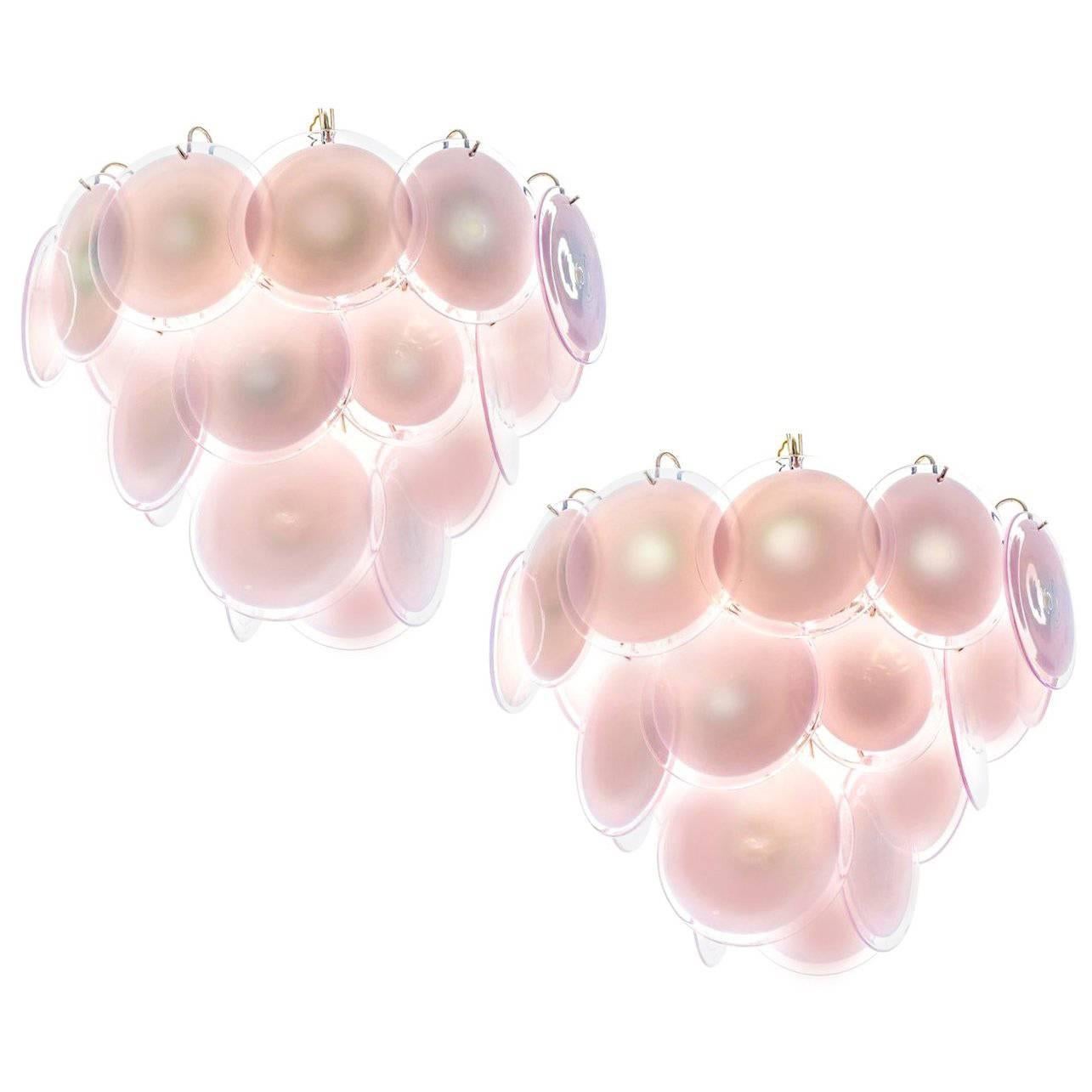 Spectacular pair of chandeliers by Vistosi made in Murano. Each chandelier is formed by 24 pink discs of precious Murano glass are arranged on floor levels. Nine lights. Measures: Height without chain 50 cm. Available also with white discs.
 