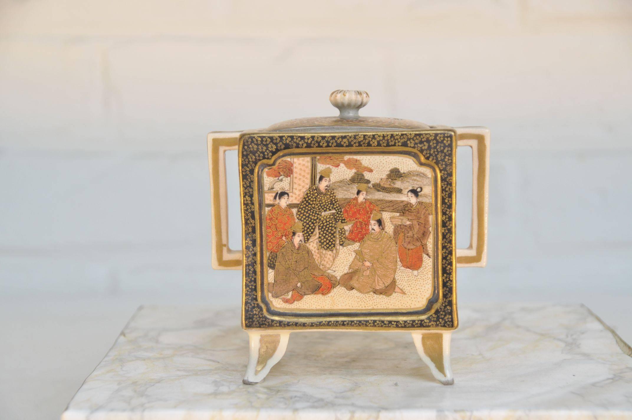 Meiji period, 19th century, marked in under glaze gilt.
The square body decorated in bright enamels and heightened in gilt, with an audience scene to front and the back alternately depicting dignitaries and ladies. Set with square shaped handles on