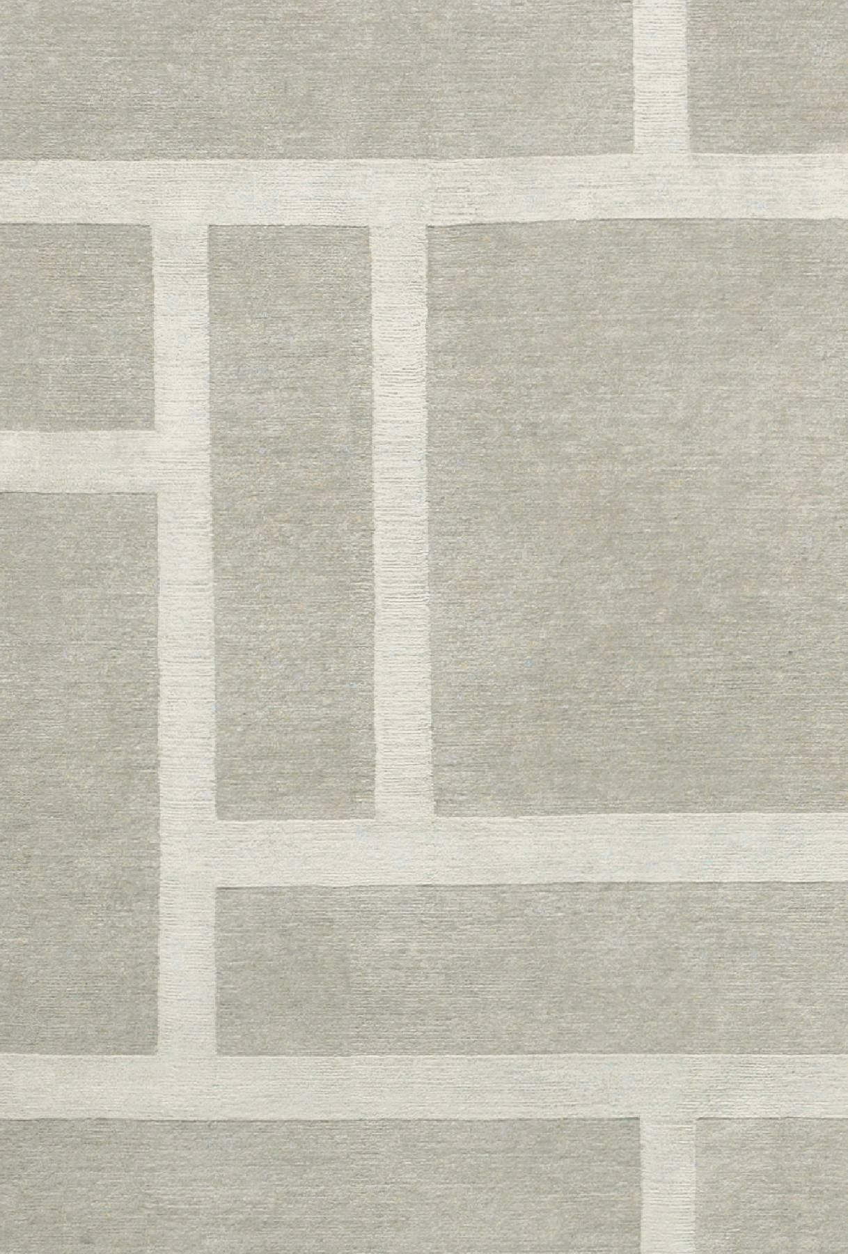 Loom rug is hand-knotted in Nepal in wool and silk (56-44%). 
Quality: 100 knots by square inch.
Base color light grey, pattern silver grey. 
Low pile, raised pattern. 

