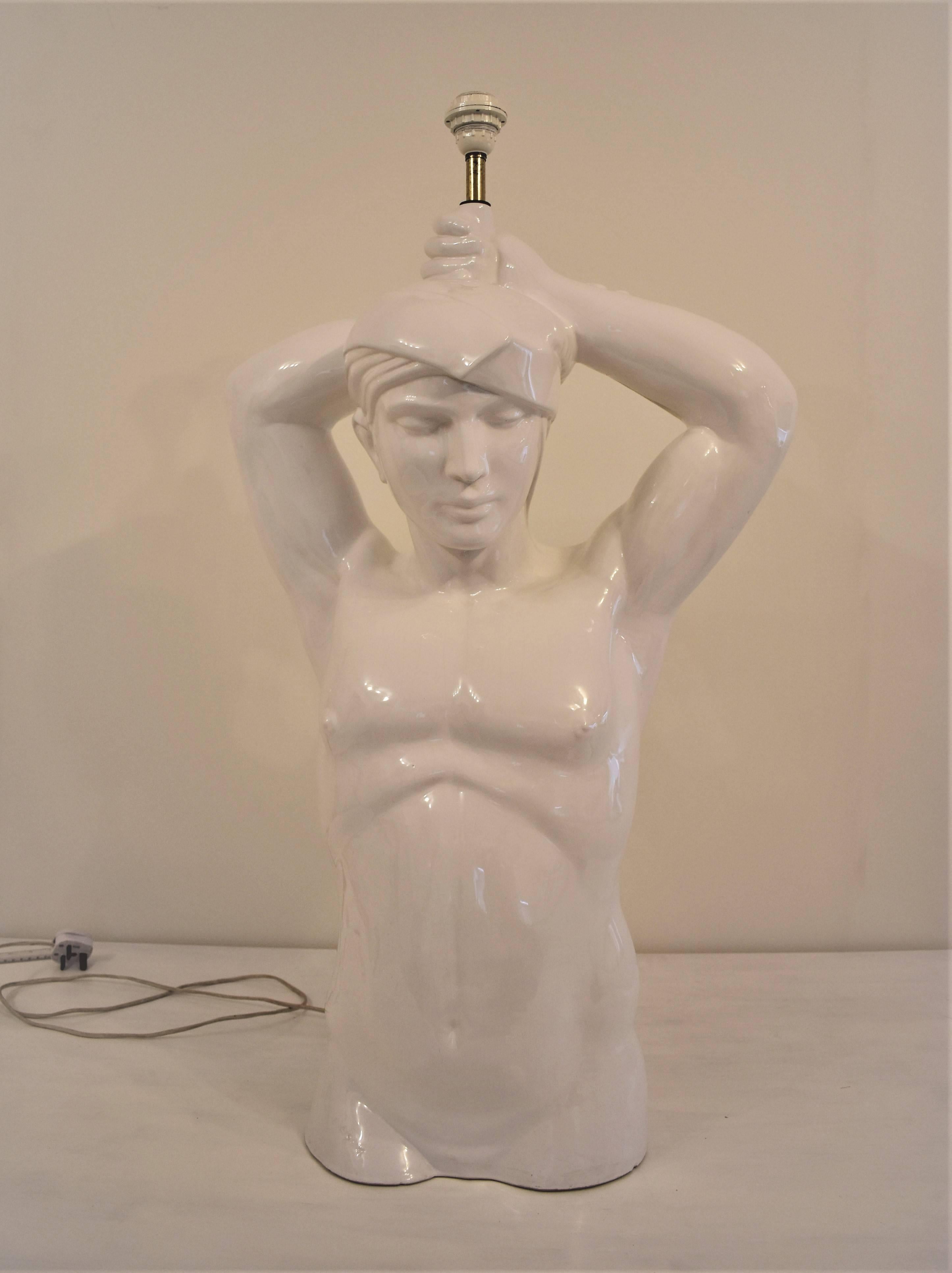 Giulio Ciniglia signed sculpture of a nude torso of a man in white glazed ceramic. Life size male figure in Art Deco style. Arms raised holding a lamp over his head. With a large original lampshade in silk. The lampshade is not in a good condition,