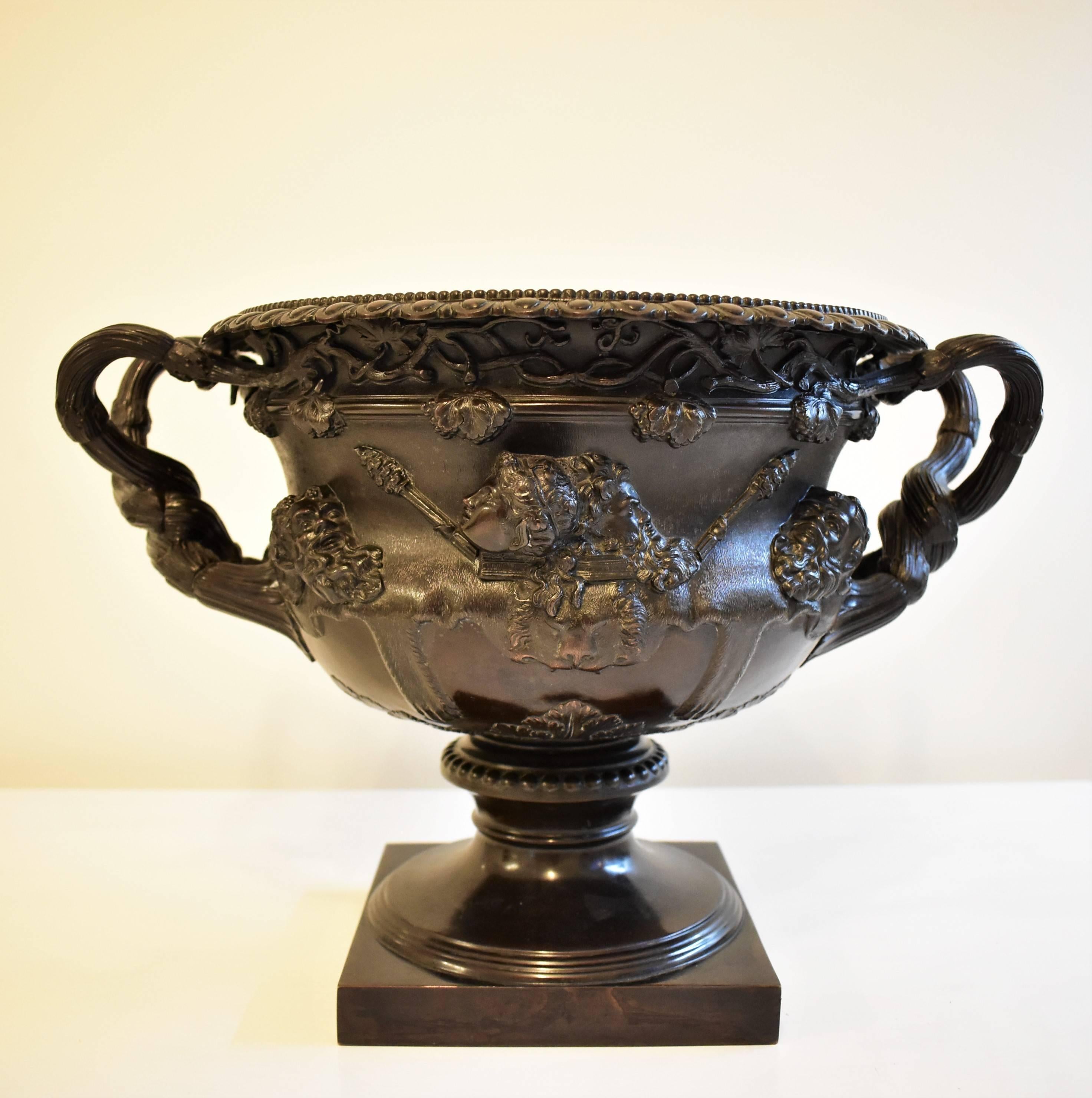 Bronze Warwick vase in perfect condition with classical motifs vines, faces, profiles. weighs 3000 grs. diameter 30 cm, with handles width 40 cm. Manufactured by Dobson & Sons London, pictured. The vase has a square bronze foot and an additional